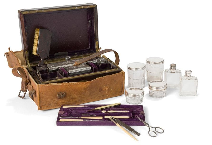 PARIS 1819 - 1838
Fabricant de nécessaire : VEDEL et Cie 91 rue de Richelieu
Nécessaire de toilette, de couture et d’écriture dans son coffre en acajou revêtu de sa protection en peau de transport et de sa clé. Il contient vingt-deux éléments composés de flacons, étuis, boîtes rondes en cristal et argent, du matériel de couture en ivoire et acier (manquent quatre éléments), une brosse et un miroir à poser. 
État : un cristal cassé et quatre éléments manquants dans les éléments de couture. 
Orfèvres : Jules COQUELIN garnisseur - le second illisible
Poids brut : 379,40 g 
Dimensions du coffre : longueur : 27 cm
largeur : 18,3 cm - hauteur : 12,9 cm