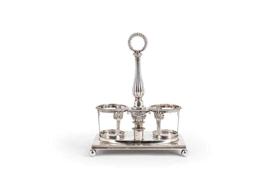PARIS 1819 - 1838Silver
oil and vinegar mak
er's frame
resting on a square base with ball feet, the decanter supports rest on papyriform sheaths, the central catch finished by a circle of pearls extends the gadrooned barrel.
Condition: the decanters are missingGoldsmith
: Hippolyte Pierre BOMPARD, inscribed in 1814Weight
:

754.70g



