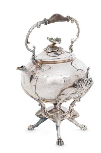 FRANCE CIRCA 1850 - 1870
Samovar en métal argenté, complet de son support et de son brûleur (manque le bouchon). Il repose sur quatre pieds griffe, le corps est uni, le couvercle sans charnière sommé d’une fleur d’hibiscus sur sa terrasse de feuilles.
Orfèvre : THOURET
Hauteur : 35 cm