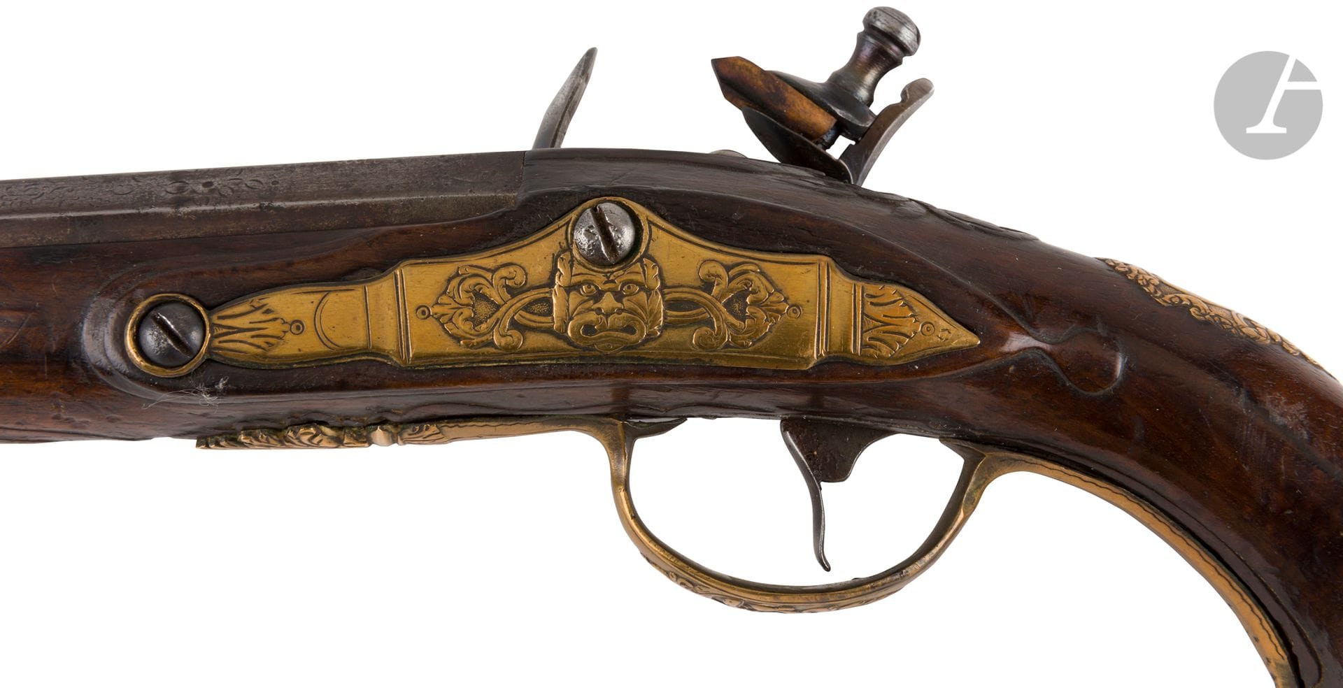 Pistolet d officier à silex.

Canon rond à pans au tonnerre gravé de fleurettes (raccourci).

Platine et chien col de cygne à corps rond, garnitures en laiton ciselé, pommeau au masque grimaçant, crosse en noyer, fêle et réparation au fût, manque la baguette.

Dans l état, vers 1760-80. Remis à silex.

Longueur du canon : 21,3 cm   Longueur totale : 37,5 cm