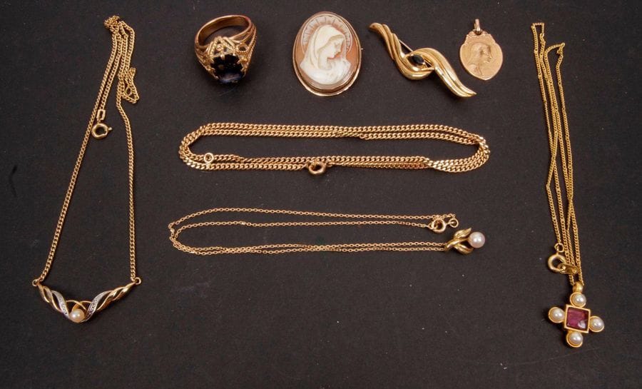 Lot de bijoux en or (majoritairement 18 K). Poids brut : 33,6 g 
Une broche feuillage sertie d'une pierre bleu, 1 médaille mariale, une broche sertie d'un camée coquille, une bague sertie d'une pierre violette, 2 chaînes et un pendentif serti d'une perle.

On joint 2 colliers fantaisie.
