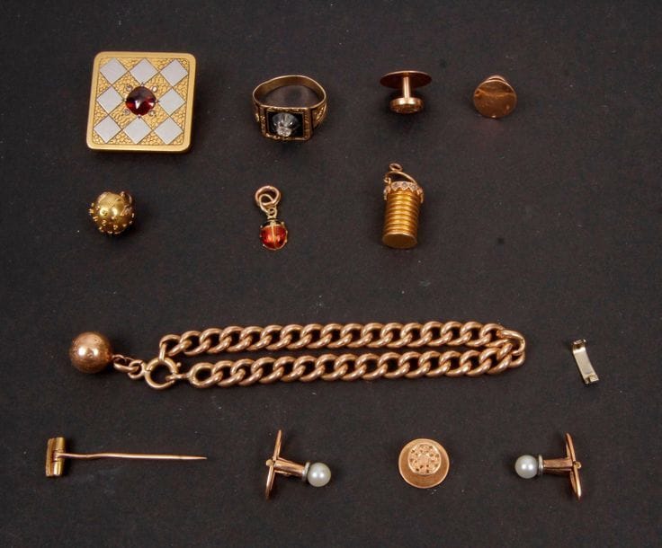 Lots de bijoux en or (majoritairement 18 K. )Poids brut : 22 g 
Une gourmette, 5 boutons de col, 3 pendentifs, 1 bague, 1 broche losangique (accident).