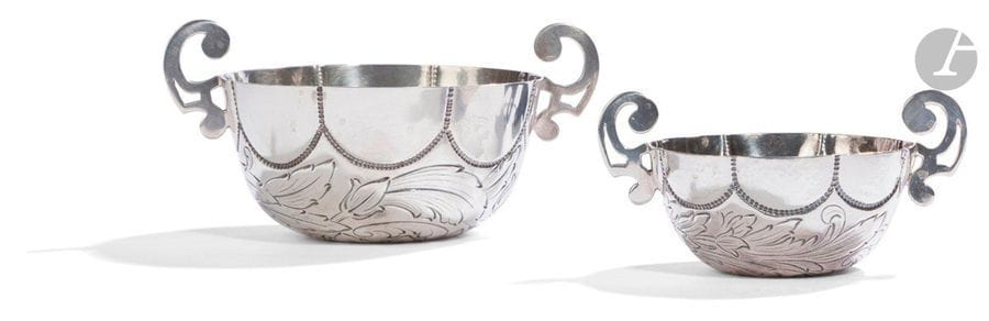 PORTUGAL - PORTO XXe siècle
Deux coupes à boire de deux tailles, à anses latérales de forme circulaire en argent 925 ‰, repoussées de larges godrons en bordure et de motifs feuillagés sur le pourtour encadrant une fleur centrale au revers, à l’imitation des coupes d’Amérique du Sud.
Orfèvre : TOPAZIO
Poids net : 322,70 g - diamètre sans les anses : 8,6 cm - 11,5 cm