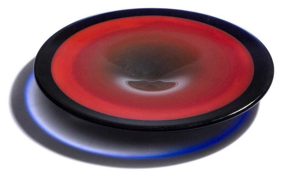 Jan EXNAR [tchèque] (né en 1951) pour BERANEK
Grand plat en verre fusionné rouge à bord noir et bleu. Signature de l'artiste et étiquette de la verrerie sous la base. Circa 1990.  
(Rayures).
Diamètre : 40 cm