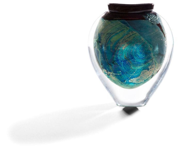 Allain GUILLOT [français] (né en 1948)
Vase en verre soufflé de forme aplatie à col ourlé dans les tons vert et bleu, pailleté d’or et d’argent. Signé, daté 1992 et numéroté 2-76 sous la base. 
Hauteur : 18 cm - Longueur : 15 cm - Profondeur : 5 cm