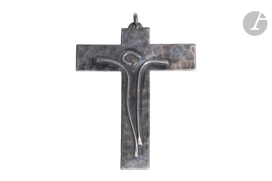 JEAN DESPRÉS (1889-1980)
Crucifix
Pendentif. Épreuve en métal argenté, l’avers entièrement martelé, le Christ stylisé en application. Oxydations et rayures superficielles éparses. Signé du cachet Jean DESPRES et porte l’inscription Lycée Pasteur 1969 au revers. H.10,5cm – L.8,3cm 