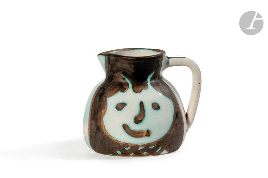 PABLO PICASSO (1881-1973) & MADOURA 
Têtes, le modèle créé en [1956]
Pichet tourné.
Réplique authentique éditée et réalisée à cinq cents exemplaires chez Madoura.
Épreuve en terre de faïence blanche, décor à la paraffine oxydée; émail blanc, noir.
Porte les cachets en creux Édition PICASSO et MADOURA Plein Feu et la marque Édition PICASSO en réserve sous la base. 
H.13cm – L.16cm

Bibliographie:
Alain Ramié - Picasso, catalogue de l’œuvre céramique édité 1947-1971- Éditions Madoura, 1988. Modèle identique reproduit page189 et référencé sous le numéro 367.