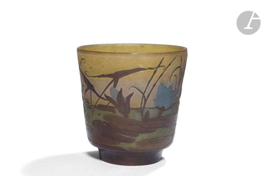 ÉTABLISSEMENTS GALLÉ (1904-1936)
Marais aux sagittaires et aux nénuphars
Vase cornet sur talon. Épreuve en verre multicouche; le décor dégagé à l’acide traité brun et bleu sur fond jaune, gris et vert. Légers frottements sur le corps du vase. Signé GALLÉ, en réserve gravé en camée à l’acide dans le décor. H.15cm 