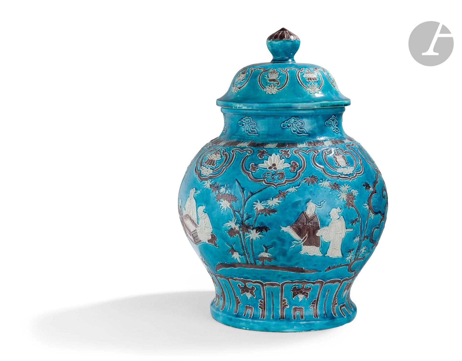 Paire de potiches en porcelaine à décor dans le style Fahua, Chine, XIXe siècle
Émaillée bleu turquoise, crème et manganèse imitant la technique des fahua (dessins cloisonnés par des filets d’argile en relief) de l’époque Ming. Décorées au col d’une frise de nuages stylisés dont la forme est inspirée des champignons lingzhi. En dessous apparaît, émaillée crème et manganèse, une frise de têtes de ruyi ornée d’un lotus dans lesquelles sont insérés en alternance les huit trésors bouddhiques. La panse est décorée de lettrés jouant au go et d’autres admirant une peinture en hauteur au milieu des bambous. La base est ornée d’une frise de panneaux de feuilles de lotus et de lambrequins, décor caractéristique des productions fahua du XVe siècle. Les couvercles sont aussi ornés d’une frise représentant les huit trésors bouddhiques et d’une prise en forme de joyau sacré.
Hauteur : 49 cm