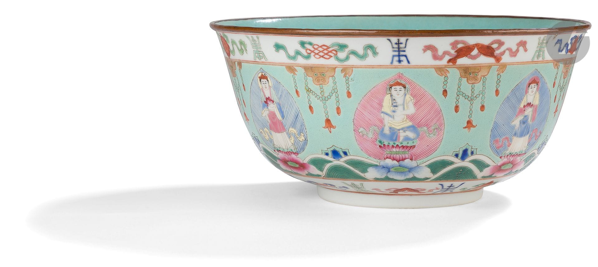 A Baragon Tumed famille rose porcelain bowl, China, 19th century, Daoguang period (1821-1850
)Decorated at the top and bottom with a frieze of famille rose enamels depicting the eight Buddhist emblems, each alternating with a shou character. Under the upper frieze are lion masks with tasselled garlands. Between each mask, in the centre of the bowl, alternate representations of bodhisattvas in leaf-shaped panels supported on flowering lotuses above stylized waves and rocks. The interior of the bowl as well as the heel are glazed in turquoise blue. In the center of the heel, the mark in red over glaze on a white background "Baragon Tumed" inscribed in Mongolian within a double square. The rim of the bowl is ringed with copper.
Height: 11 cm; diameter: 23.5 cmThis

large bowl in the Baragon Tumed style is inspired by the service created in 1842 during the Daoguang reign for the marriage of one of his daughters to a Mongolian Tumed prince

.

