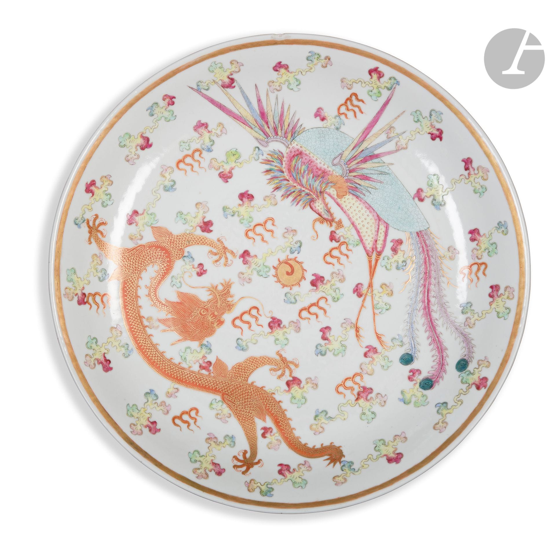 Porcelain dish decorated in the famille rose style, China, Guangxu mark and period (1875-1908
)Decorated with a five-clawed dragon and a phoenix facing each other around the flaming pearl among stylized clouds and flames. The reverse side is decorated with three floral motifs. Guangxu mark with six characters in iron red on the base.
Diameter : 37 cm 
A chip on the marli.


