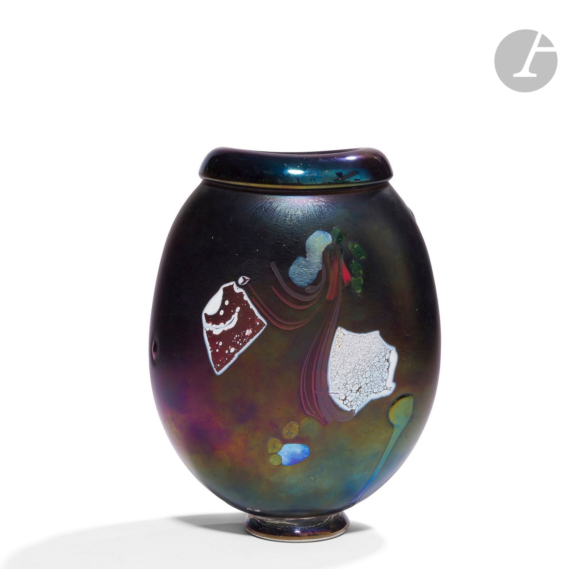 ROBERT PIERINI [français] (né en 1950)
Grand vase sur talon en verre soufflé à col ourlé, de forme ovalisante, à décor de plaques de couleurs appliquées sur un fond bleu marine irisé. Signé, daté 1988 et numéroté C.04 sous la base. 
H.26 cm - L.20 cm - P. 12 cm