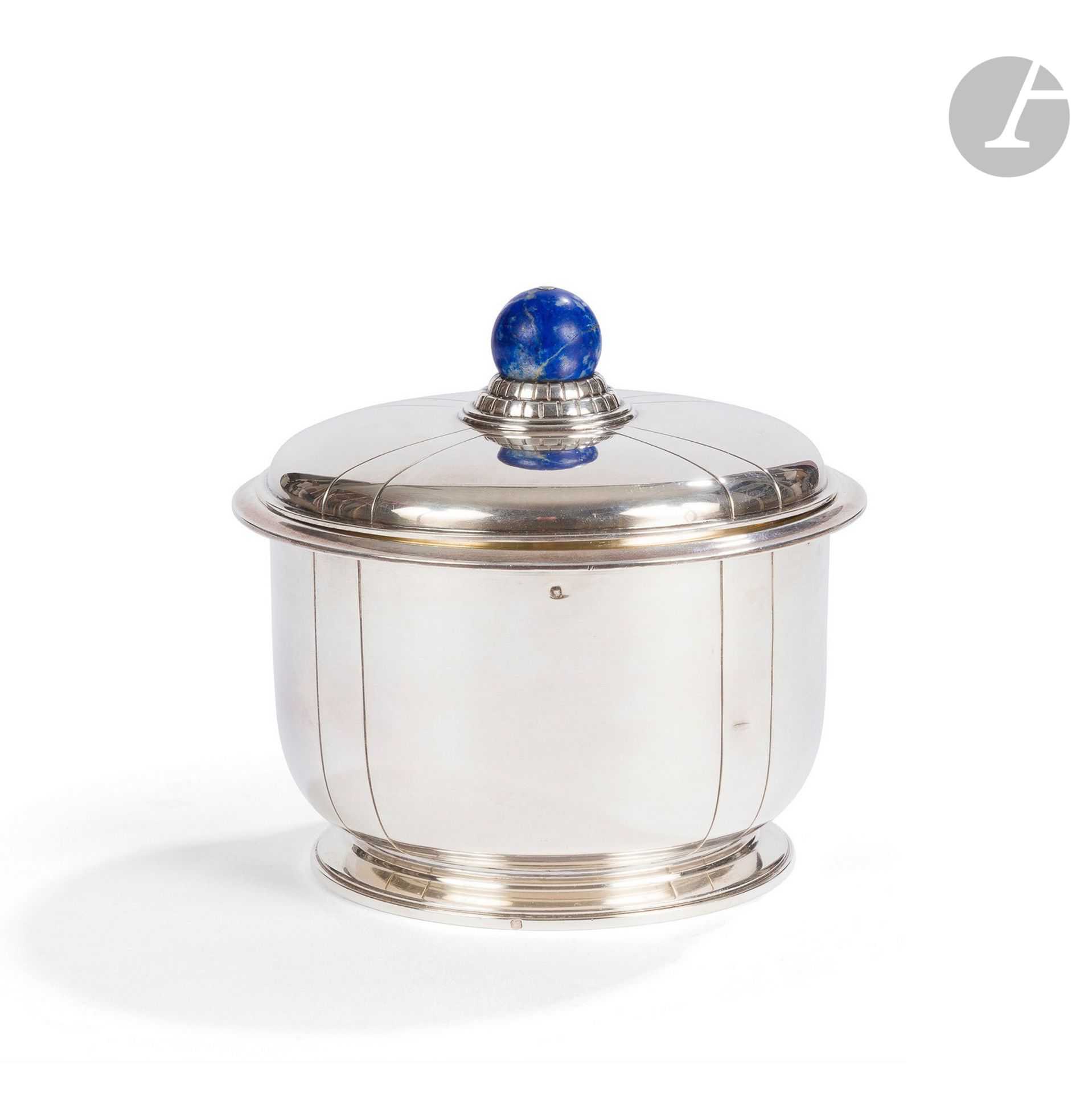 JEAN-ÉMILE PUIFORCAT (1897-1945) (JEAN-ÉLISÉE PUIFORCAT, DIT) 
Pot couvert cylindrique, formant boîte à biscuits, reposant sur une base circulaire présentant un étranglement. Épreuve en argent. Le couvercle et le pourtour aux motifs de fines lignes gravées. La graine sphérique en lapis lazuli d’origine et accueillie par une base en gradins rainurés. Marqué Jean E. PUIFORCAT sous la base et porte à deux reprises le poinçon de garantie sur la base. H. 13 c m - D. 13,5 cm – Poids brut : 564 g

Bibliographie :
- Art et Décoration – N° 6 de 1923. Légère variante reproduite page 23.
- L’Amour de l’Art – N° 4 de 1924. Légère variante reproduite page 125.