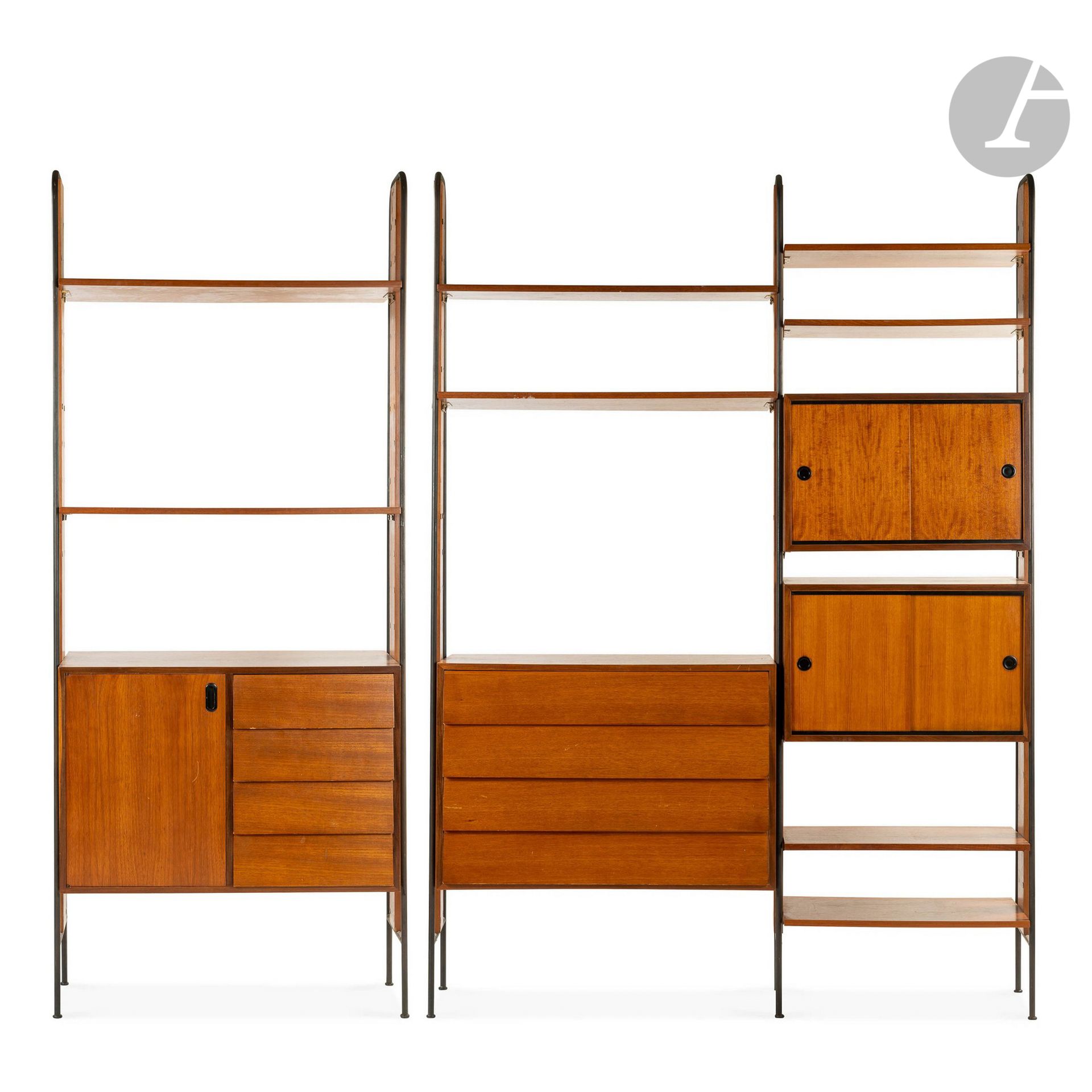 TRAVAIL DES ANNÉES 1950
Deux meubles-étagères de salon, l’un double, l’autre simple, composés chacun d’éléments modulables en placage de teck. Les montants, en léger trapèze et cintrés en partie haute, réalisés en métal tubulaire laqué noir. La double unité reçoit 4 tablettes et 3 caissons (l’un recevant 4 tiroirs et les 2 autres ouvrant par des portes coulissantes). L’unité simple accueillant 2 tablettes et 1 caissons ouvrant par 4 tiroirs et une porte pleine. Quelques pièces de quincaillerie manquantes, sauts de placage épars. La double unité : 229 x 159 x 40 cm - L’unité simple : 229 x 94 x 39 cm – Le système modulable au complet : 229 x 253 x 40 cm