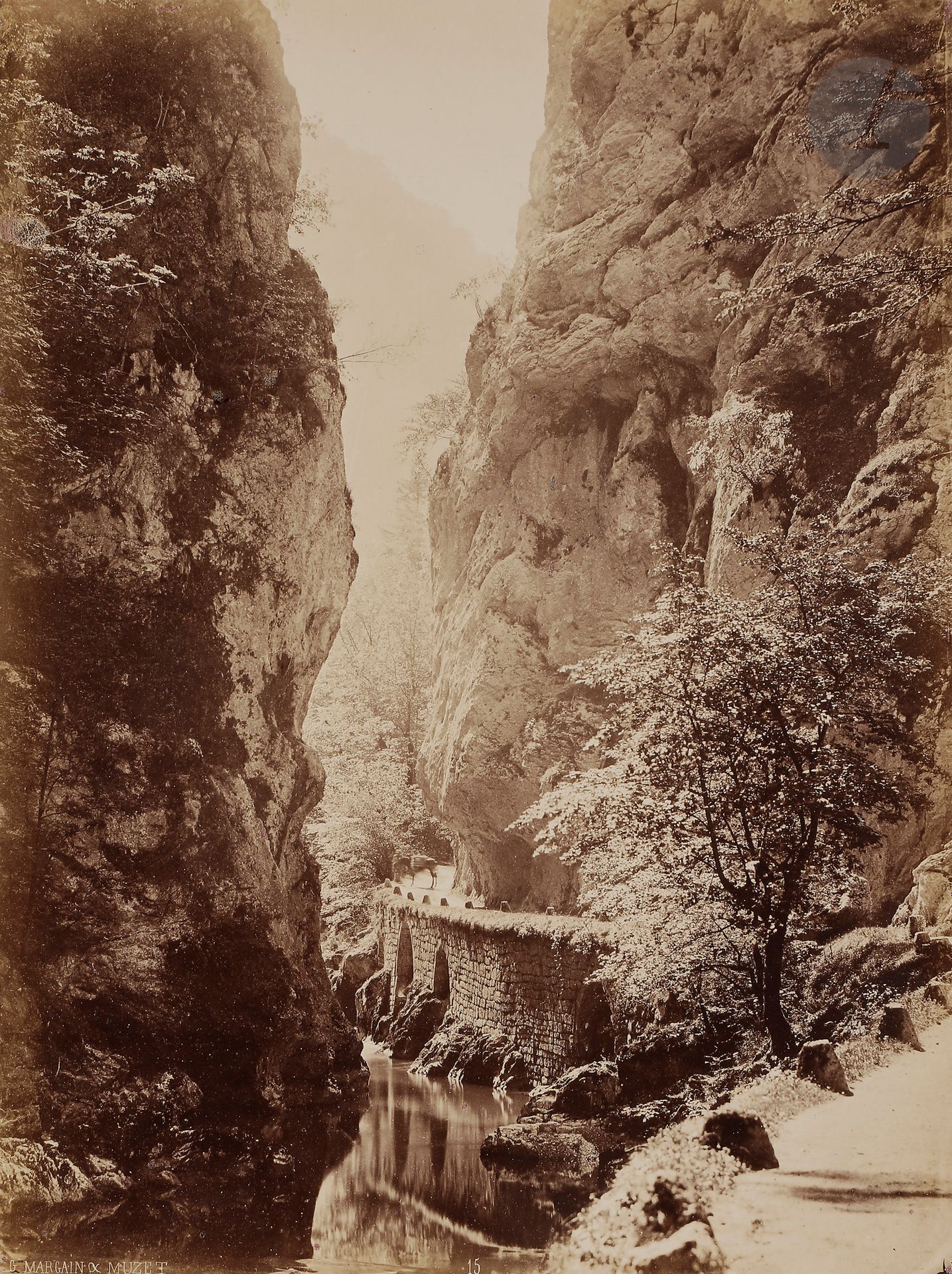 Gustave Margain (1826-1907) et Victor Muzet (1828-après 1885) 
Isère, 1865.
Entrée du désert par Saint-Laurent-du-Pont (Grande Chartreuse).
Épreuve sur papier albuminé, contrecollée sur carton. Crédit des photographes dans le négatif en bas à gauche. Légende manuscrite et timbre sec des photographes sur le montage en bas. 
35,5 x 26,4 cm 

Gustave Margain (1826-1907) and Victor Muzet (1828-after 1885) 
Isère, 1865.
Entrée du désert par Saint-Laurent-du-Pont (Grande Chartreuse).
Albumen print, mounted on cardboard. Photographer's credit in the negative. Handwritten caption and photographer's blind stamp on mount. 
35.5 x 26.4 cm