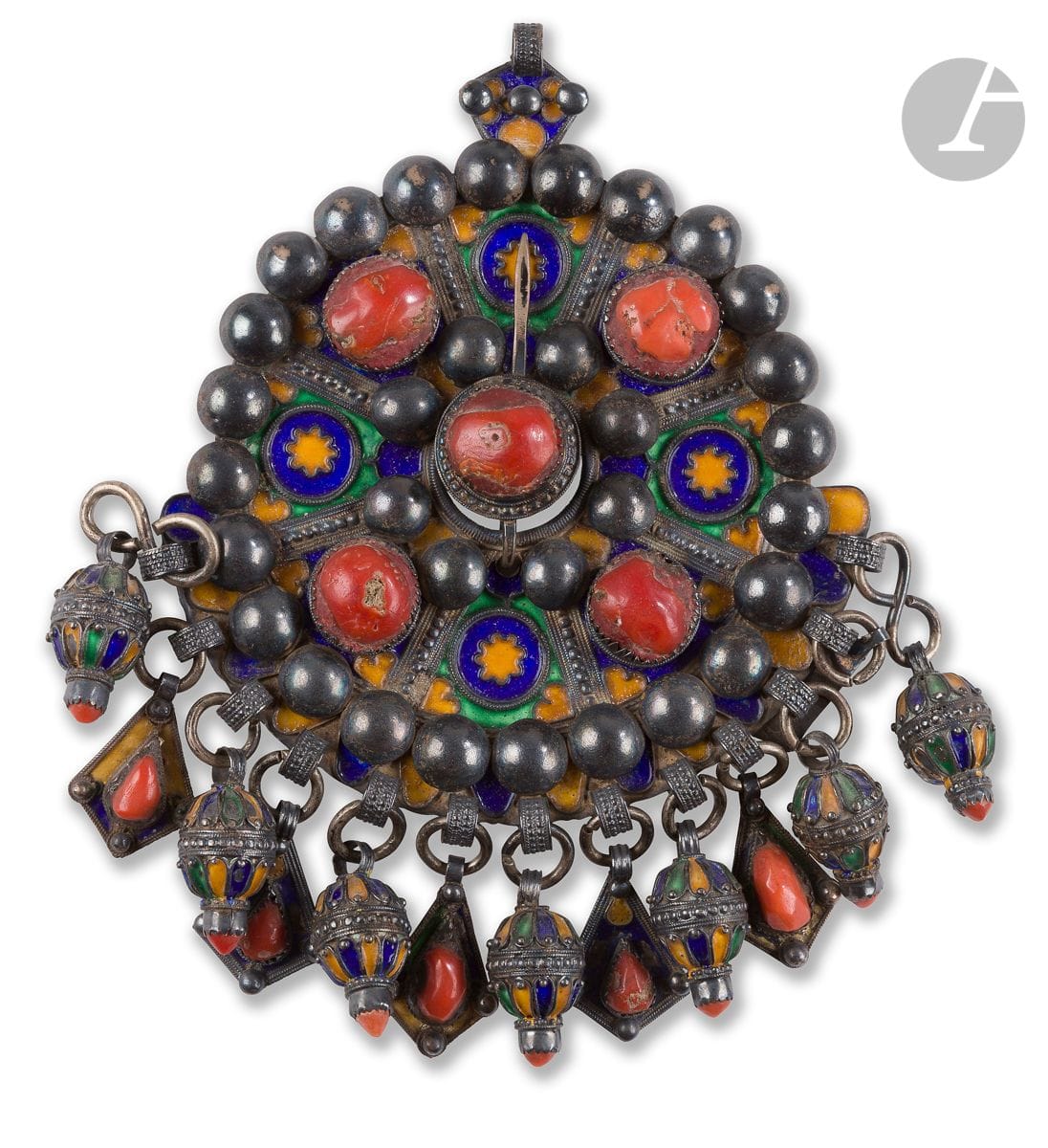 Tabzimt fibula, Algeria, Great Kabylia, Beni Yenni tribe, 19th
centurySilver round
fibula,
enamelled on a green background with blue circles and a yellow starred centre, set with five coral cabochons and encircled with applied silver beads. On the lower part, various shapes of pendants, enamelled and with coral cabochons. On the reverse side, a beautiful enamelled rosette.
Diameter: 14 cm; gross weight: 739 gThis


lot is part of the collection of Mr. Philippe Magloire


.




An enameled silver fibulae, Algeria, Great Kabylia, 19th century









