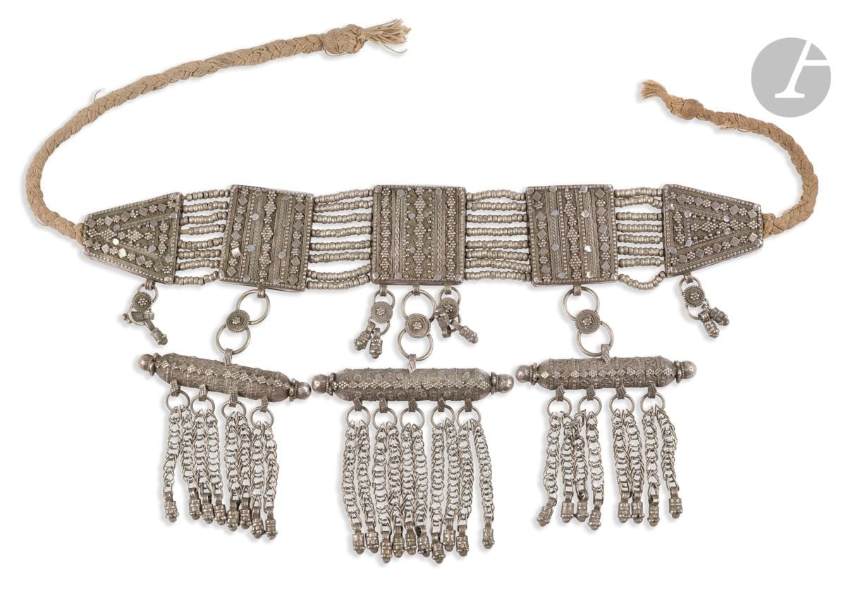 Large metal bridal talismanic necklace, Yemen, 19th-20th centuryComposed of
five geometrically decorated plates with pendants, the central three forming a hirz amulet holder.
Length: 35 cm; gross weight: 517 gAn

important talismanic bridal necklace, Yemen, 19th-20th century













