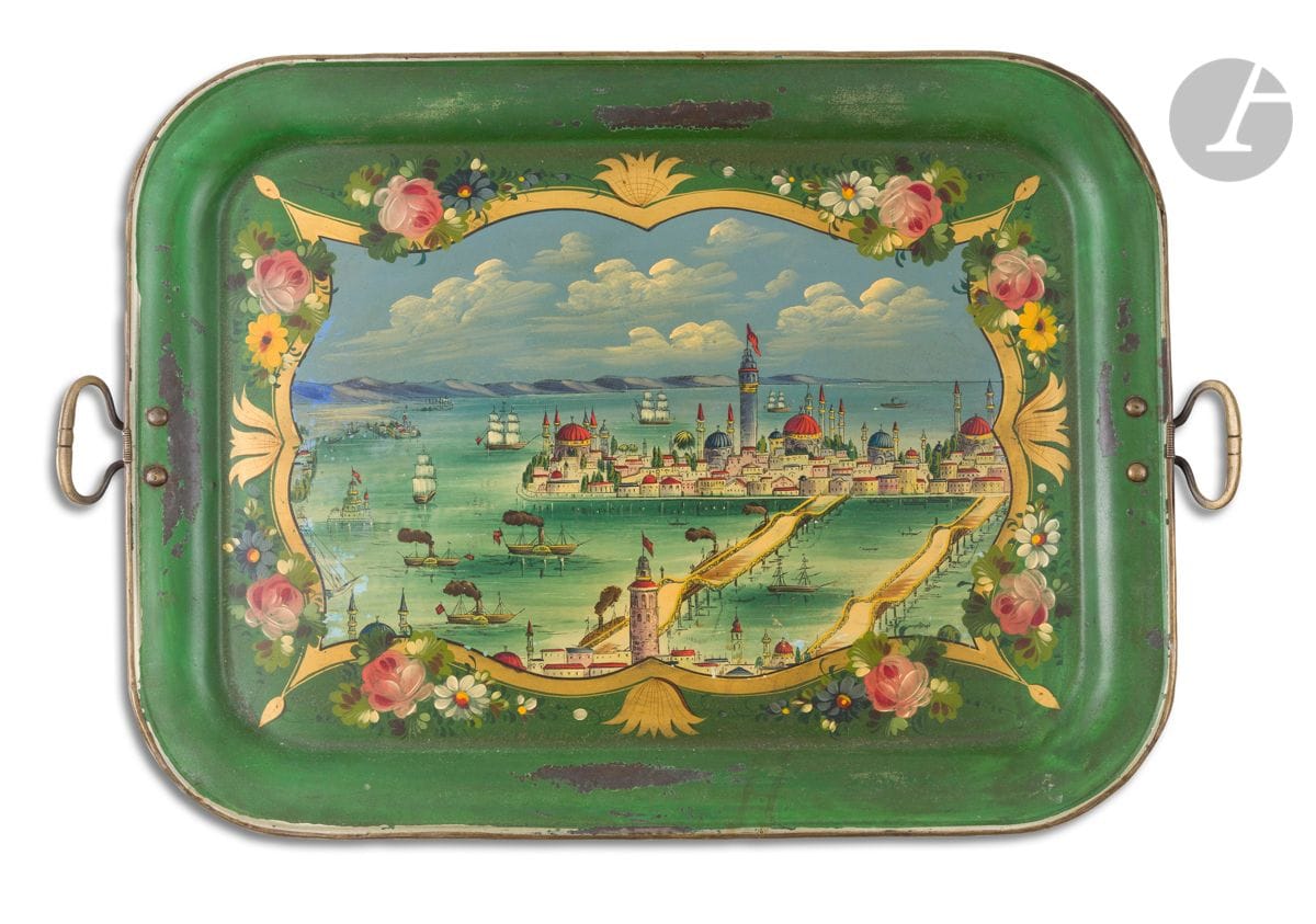 Grand plateau orné d’une vue de la Corne d’Or, Empire Ottoman, XIXe siècle
De format rectangulaire à bordure incurvée en métal peint d’un paysage dans un cartouche doré agrémenté de fleurs sur fond vert. On reconnaît une vue de la Corne d’Or à Istanbul peinte depuis les hauteurs de Galata où navires à voile et à vapeur vont et viennent.
Deux poignées rivetées sur les côtés.
43,3 x 57,5 cm (sans les poignées).
Éclats de peinture, rayures au dos.

A large painted metal tray with a view of the Golden Horn, Istanbul, Ottoman Empire, 19th century

