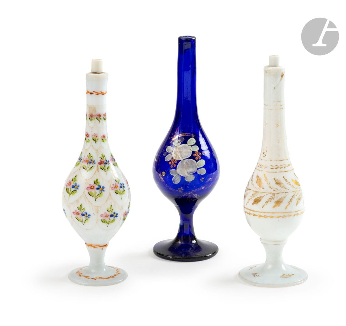 Three white opaline or blue glass aspersoirs, Turkey, Beykoz, 19th centuryTwo
in white opaline, the first with enamelled and gilded floral decoration of bouquets in scale compartments, the second with gilded vegetal branches painted on the body, the neck and the foot; the third in midnight blue glass with enamelled decoration of stylized flowers in a gilded medallion
Height: 24, 24 and 25 cmAccidents
, one stopper missing. 

Three Beykoz rosewater sprinklers, Ottoman Turkey, 19th centuryProvenance

: Marie-Christine David Collection

.




