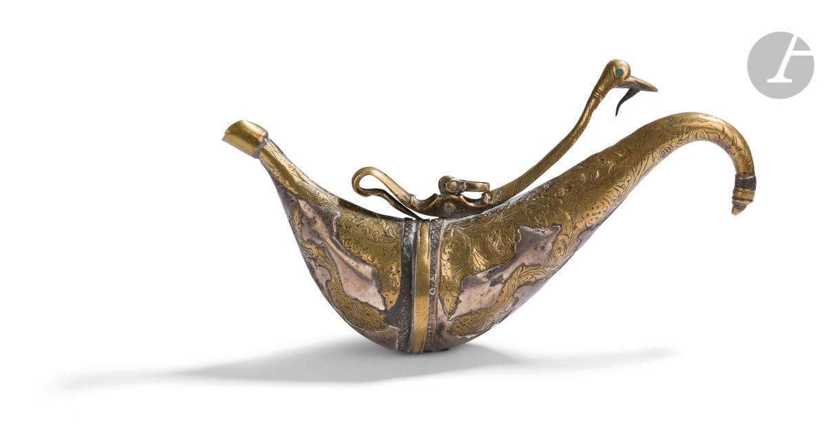 Barudani powder flask, Afghanistan, 19th or 20th
centuryChased brass, in the form of a two-part ship's hull with a curved end, with engraved floral decoration on the whole incorporating silver flowered applications. The opening and hanging system at the end is in the shape of a bird's head with an eye inlaid with turquoise glass paste.
Length : 16,3 cmSmall
lack at the opening, some shocks. 

A very similar example is kept in the Quai Branly Museum under the number 71.1967.110.633.

A barudani powder flask, Afghanistan, 19th or 20th century









 












