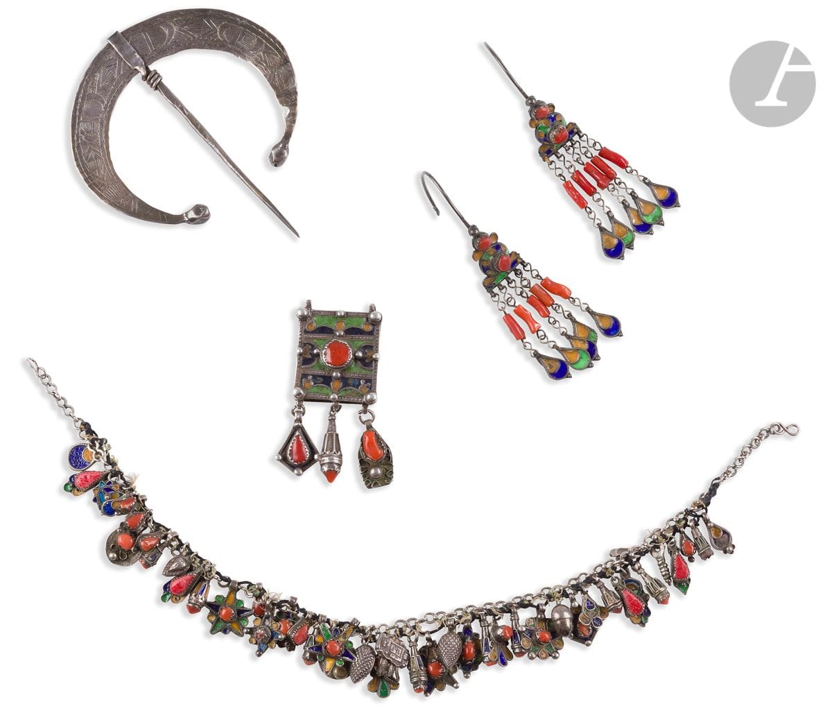 Parure de bijoux, Algérie, Grande Kabylie, Beni Yenni, XXe siècle
Parure comptant un collier en argent, une paire de pendants de coiffe et un pendentif-amulette en argent émaillé de bleu, de jaune et de rouge et corail. Le collier constitué d’une chaîne à pendeloques de formes variées ; les pendants constitués d’un anneau d’accroche menant à une plaque d’argent émaillée à cabochons de corail et maintenant des pendeloques garnies de brins de corail ; le pendentif, petite boîte rectangulaire à trois pendeloques, surmontée de deux anneaux de suspension et présentant un décor émaillé et de cabochons d’argent et de corail.
L. collier : 44 cm ; h. pendants : 12,1 cm ; H. pendentif : 8,4 cm ; poids brut : 241 g
Des sauts d’émail, quelques cabochons de corail manquants ou remplacés par de la résine rouge.
On joint une petite fibule hilal en argent ciselé d’un décor géométrique et poinçonné, Tunisie, XXe siècle. D. max. : 11 cm ; chocs. 

A set of jewellery, Algeria, Great Kabylia, Beni Yenni, 20th century

