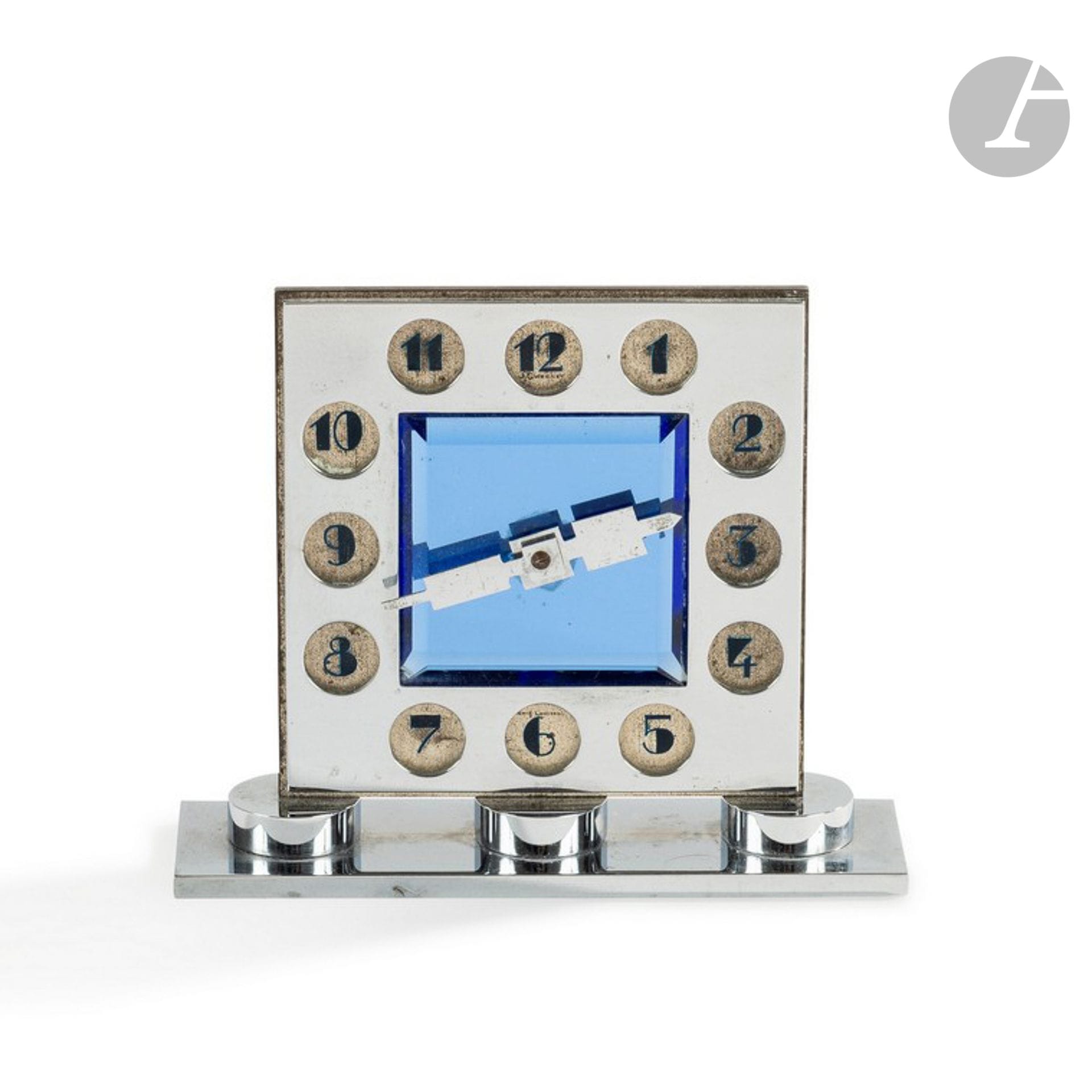 JEAN CHAUMET (1852-1928) – MAISON CHAUMET PARIS-LONDRES
Rare pendulette moderniste en métal chromé.
Le corps carré présente une partie centrale en miroir bleuté et biseauté et des réserves circulaires recevant les chiffres émaillés bleu sur un fond de métal nickelé. 
La base rectangulaire est rythmée de trois palets accueillant la partie haute.
Aiguilles en métal découpé et chromé.
Mouvement mécanique à remontage manuel par Ch. Hour Paris.
Circa 1925-30.
Oxydations et usures aux parties nickelées (plaque de fond).
Vendue dans son écrin à volets d’origine marqué J. Chaumet – Paris 12 place Vendôme – Londres 22 Brubon street.
Marquée J. CHAUMET dans la réserve du 12 et Paris-Londres dans la réserve du 6.
Hauteur : 9,5 cm – Longueur : 11,5 cm – Profondeur : 3,5 cm

Provenance :
Succession X., Montrouge.