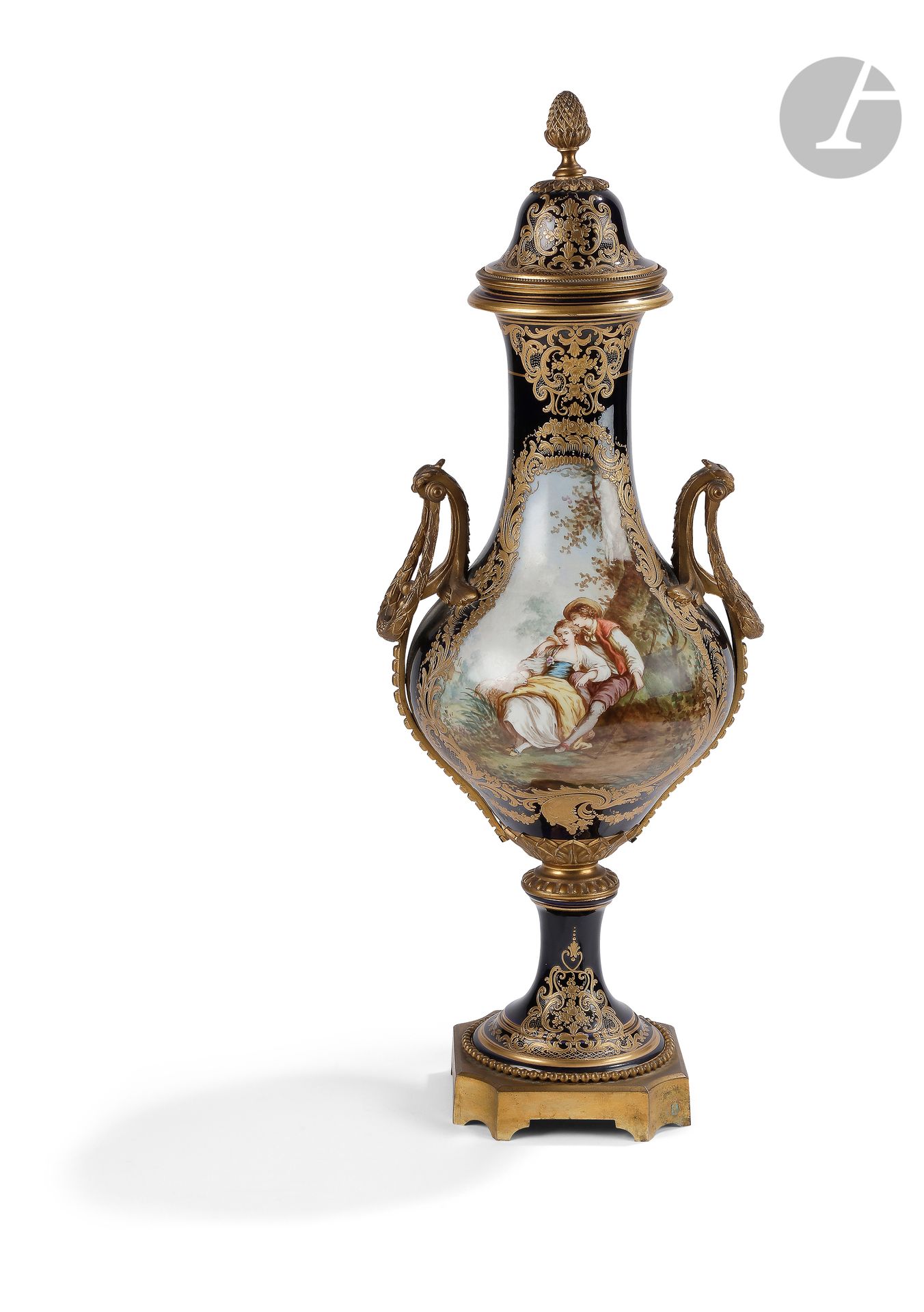 Sèvres (genre de)
Vase balustre couvert en porcelaine à décor polychrome de couples galants dans le style de Boucher et paysage dans des réserves sur fond bleu orné de rinceaux rocaille or, la base, les anses et la prise du couvercle en bronze doré.
Marque apocryphe de Sèvres.
XIXe siècle, vers 1880.
H. 63 cm