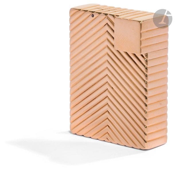 CARTIER Paris. Briquet à essence en or jaune 750 0/00. Décor de godrons en chevron. Numéroté : 612507. H : 4.5 cm. Pb : 48.31 g