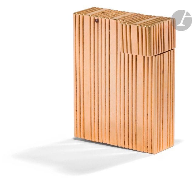 CARTIER Paris. Briquet à essence en or jaune 750 0/00. Décor de cannelures verticales. Numéroté : C7883. H : 4.7 cm. Pb : 51.08 g