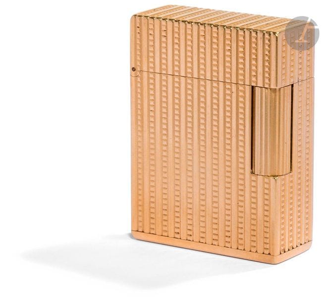 ST DUPONT Paris for CARTIER. Standard (BS) gas lighter in yellow gold 750 0/00. Alternating decoration of vertical stripes and nails of Paris. Numbered : B1361. H : 4.6 cm. Pb : 105.36 g._x000D_

For the English market.