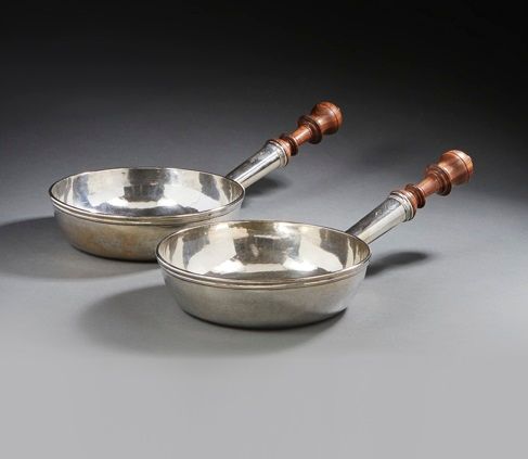 RENNES 1751 - 1752
Paire de poêlons en argent uni, la bordure moulurée de filets et rivetée, manche en bois tourné, vissé dans sa hotte gravée d’armoiries d’alliance de MENOU / COCHON de MAUREPAS. Bonne Émilie Cochon de Maurepas (1734 - 1800) épouse en 1751 Louis-Joseph II de Menou-Cuissy (1725 - 1794). Manches en bois probablement d’époque postérieure.
Au revers, gravée des poids en anciennes mesures : 3 Marcs 5 Onces pour une, 3 Marcs, 4 Onces, 6 Grains pour la seconde.
Maître orfèvre : Michel-Eloy LETAILLEUR, reçu en 1739.
Poids brut : 1911,5 g - diamètre : 22,5 cm - longueur au manche : 44 cm