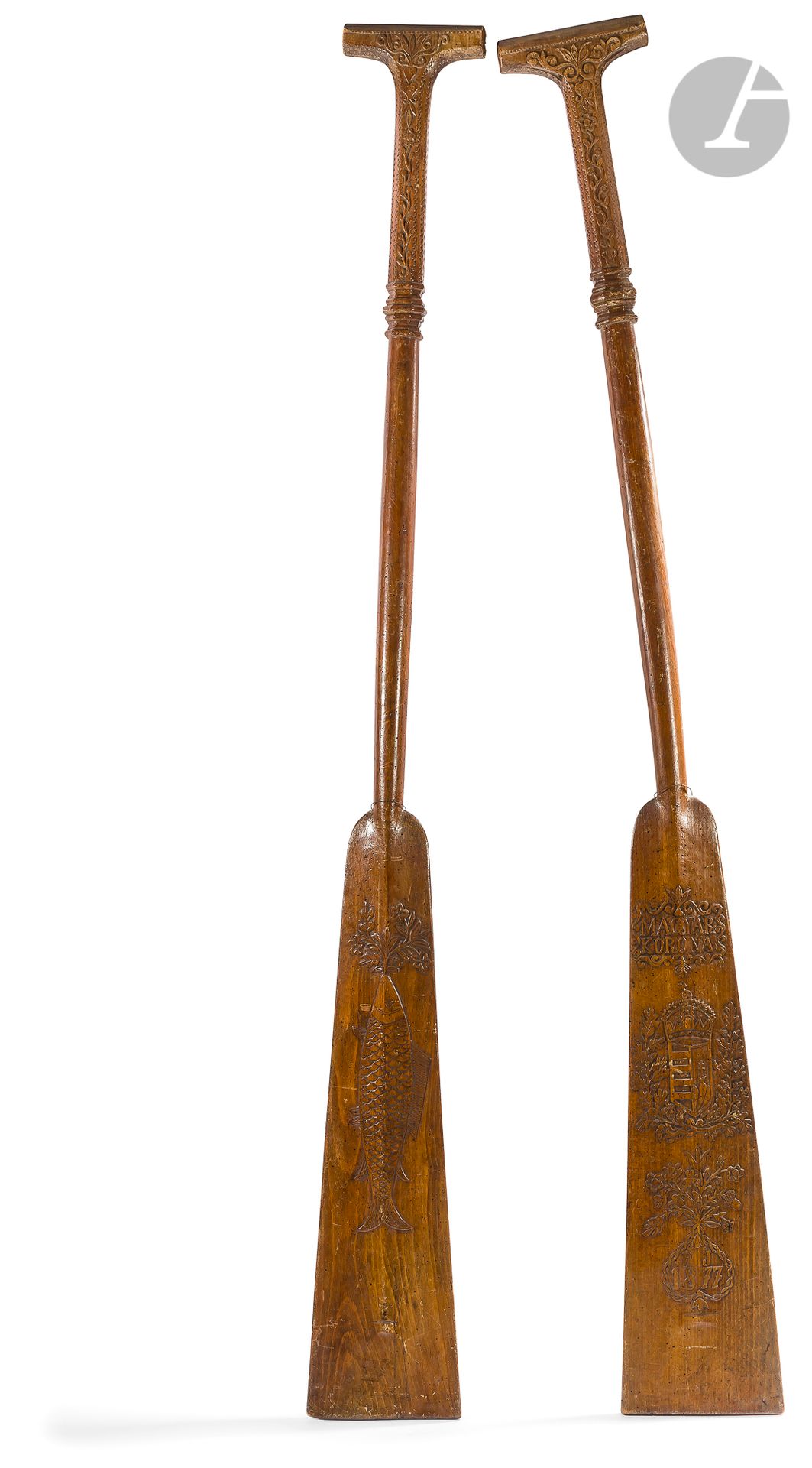 HUNGARY 1877
Two canoe paddles, carved on wood. They bear on one side the arms of Hungary, stamped with the crown of Saint-Etienne and the date of completion: 1877 in foliated and flowered frames. On the reverse side are two fishes carved. The handles with handles, with sides, are carved with floral motifs framed with geometric motifs. 
condition: many wormholes.
L: 162 cm - W: 17.8 cm