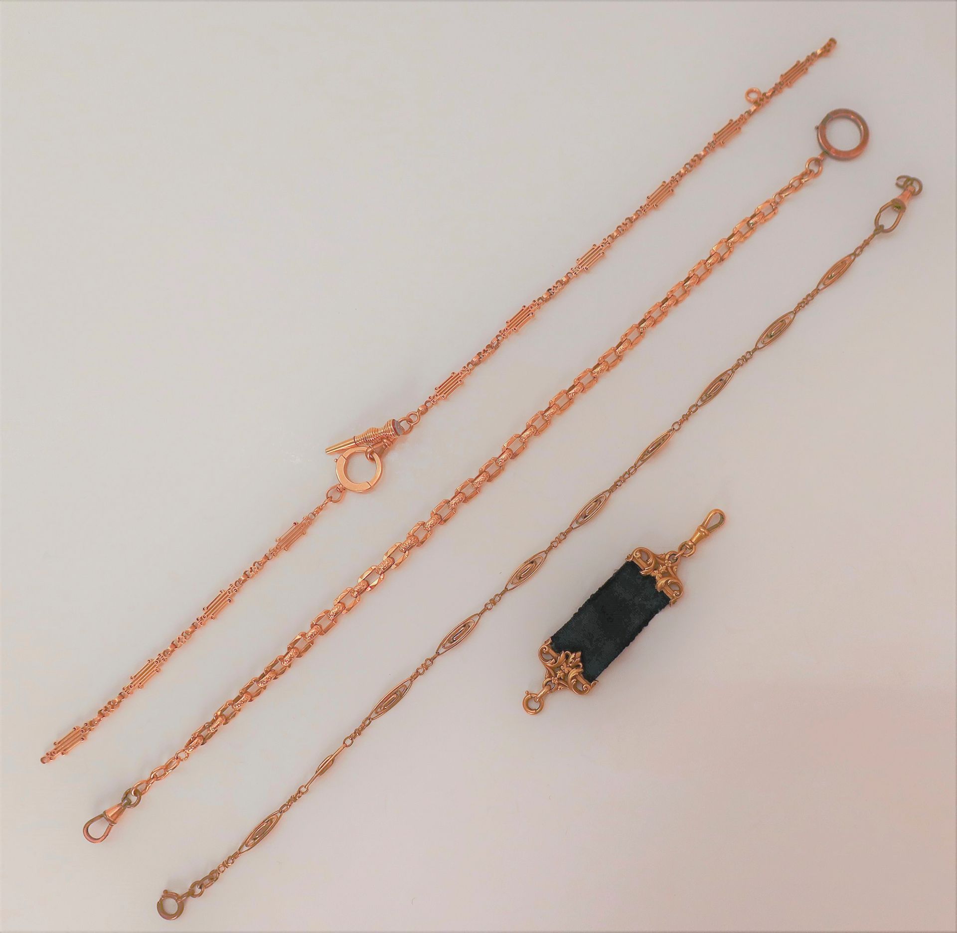 
Lot de 2 chaînes giletières en or 18K) et une giletière en or (20K) et ruban.

Poids brut : 39,8 g

On joint une chaine en métal doré.

