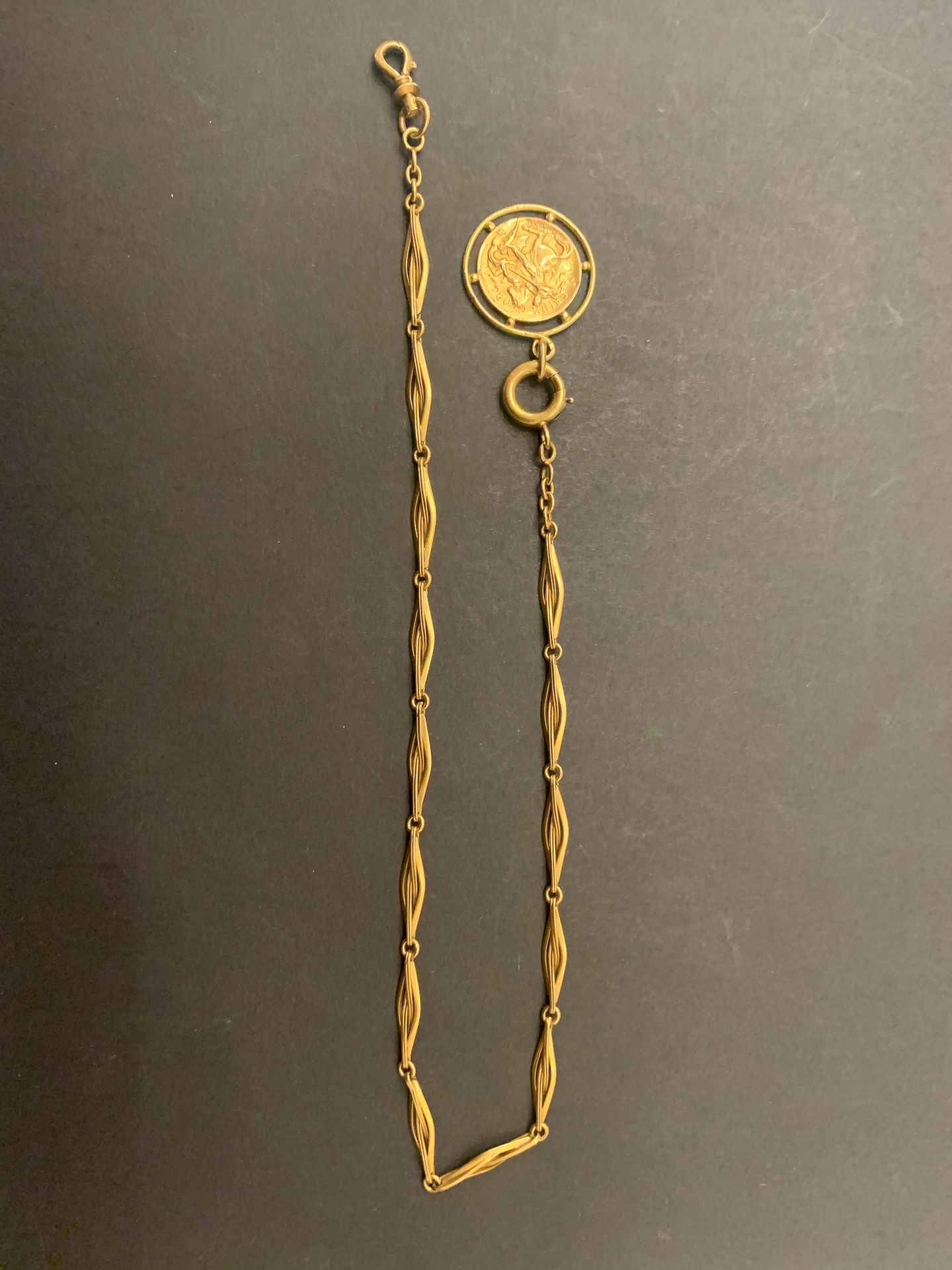 
Une chaine de montre en or (18K) et une médaille de St Georges. Poids : 16,1 g
