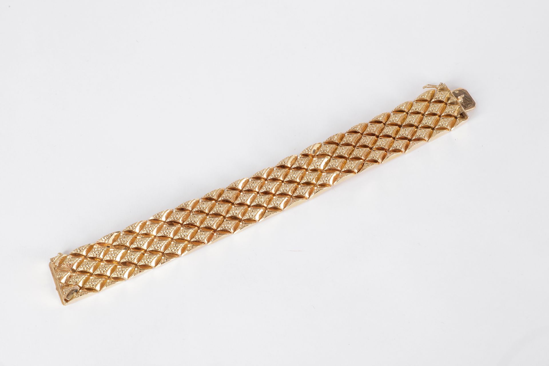 
Bracelet ruban en or (18K) à motifs losangiques. Poids: 59,4 g
