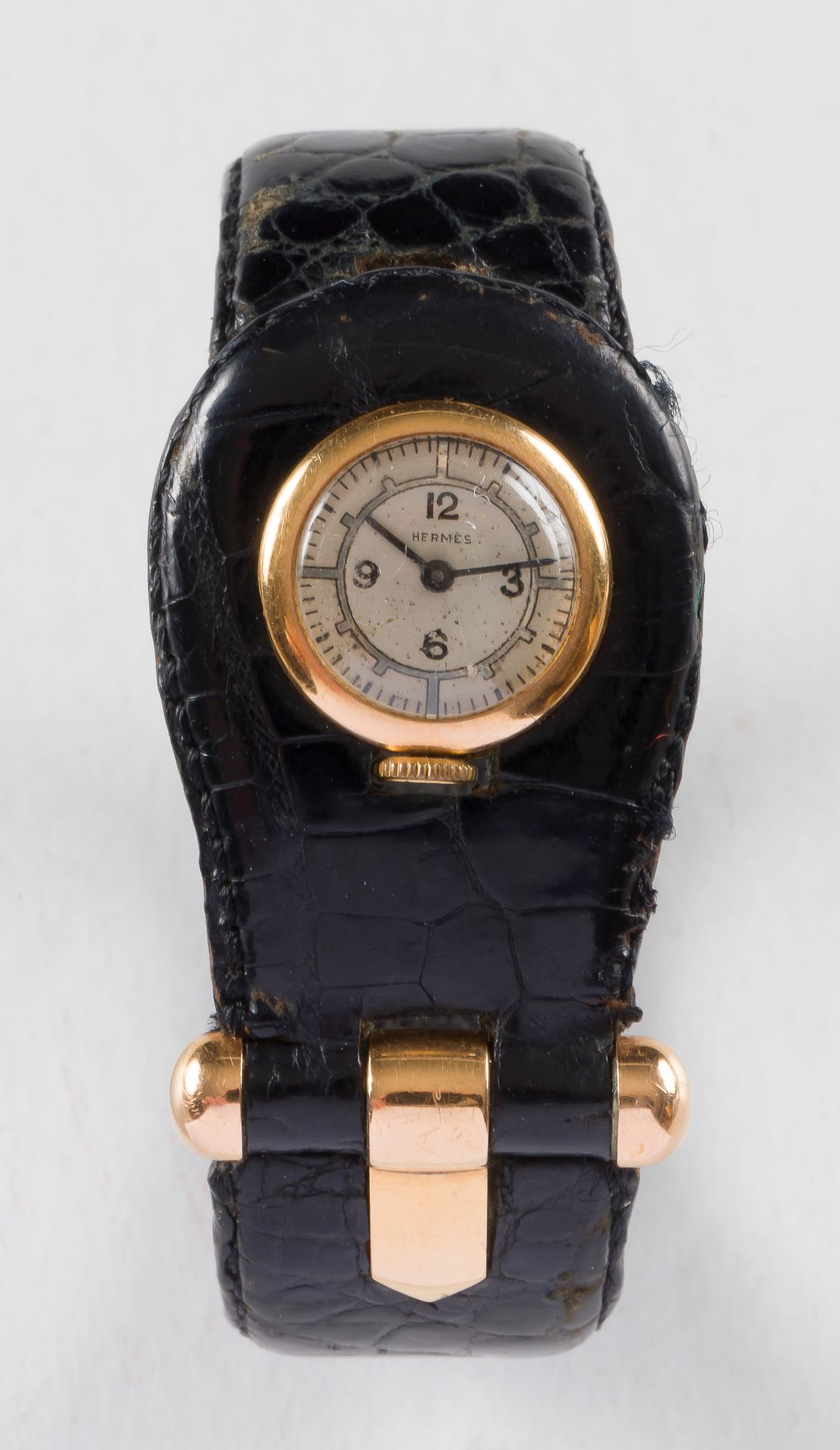 Hermès. Vers 1940.

N°13776

Montre bracelet de dame en or 18K (750) intégrée dans un bracelet en cuir noir. Cadran en argent (piqué), index chiffres arabes formant les heures. Mouvement à remontage mécanique de marque Mido.

Poids brut : 37,10 g

Usures d’usage du bracelet