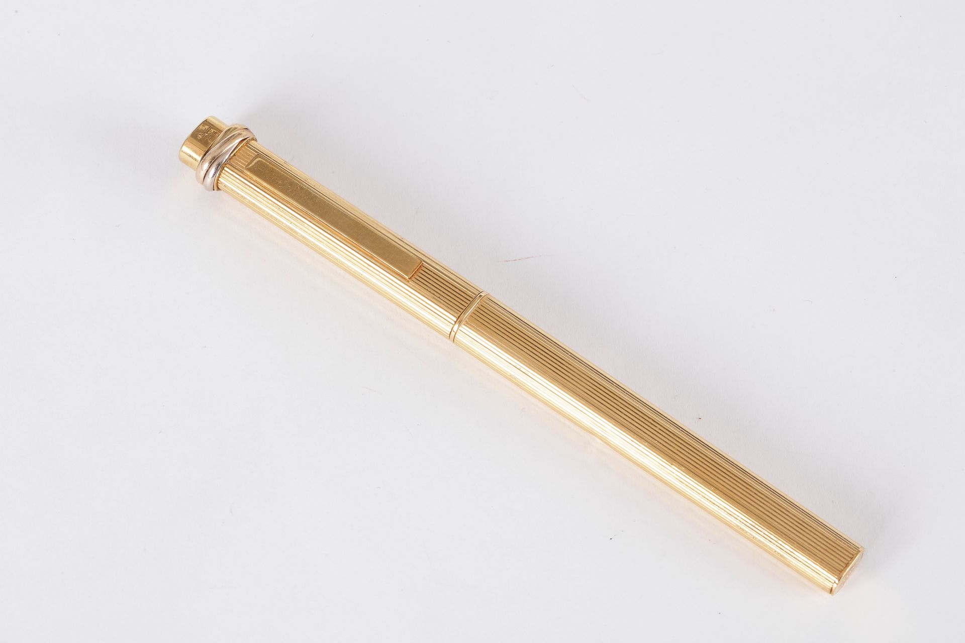 CARTIER.

Stylo-bille en métal doré. Signé. 

Dans sa pochette en suédine.