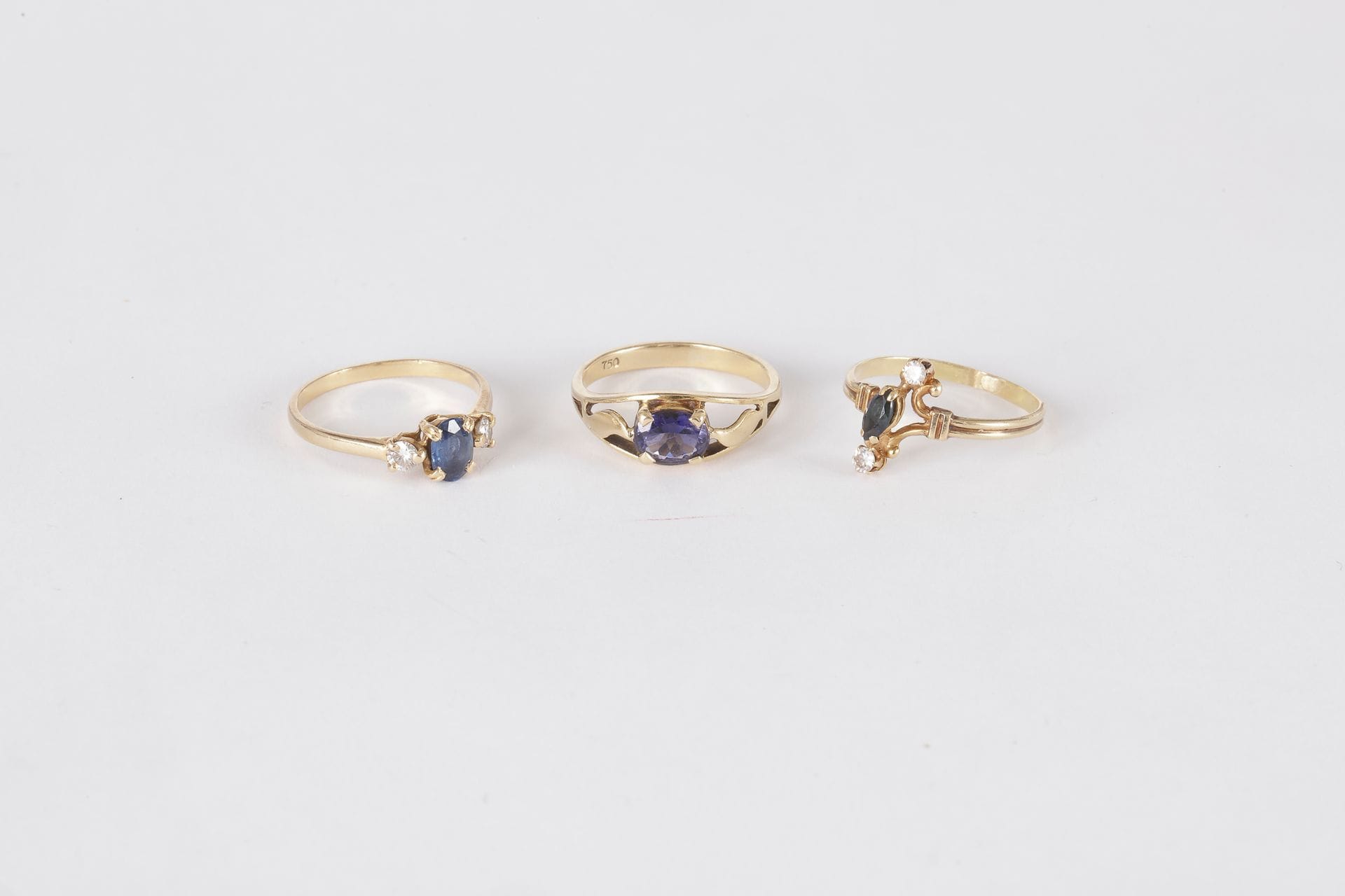 Lot de bagues en or 18K (750) : la 1ère ornée d’une cordiérite, la 2ème sertie d’un saphir navette et de deux diamants ronds, la 3ème ornée d’un saphir ovale épaulé de deux diamants ronds de taille brillant. 

Poids brut : 7,5 g