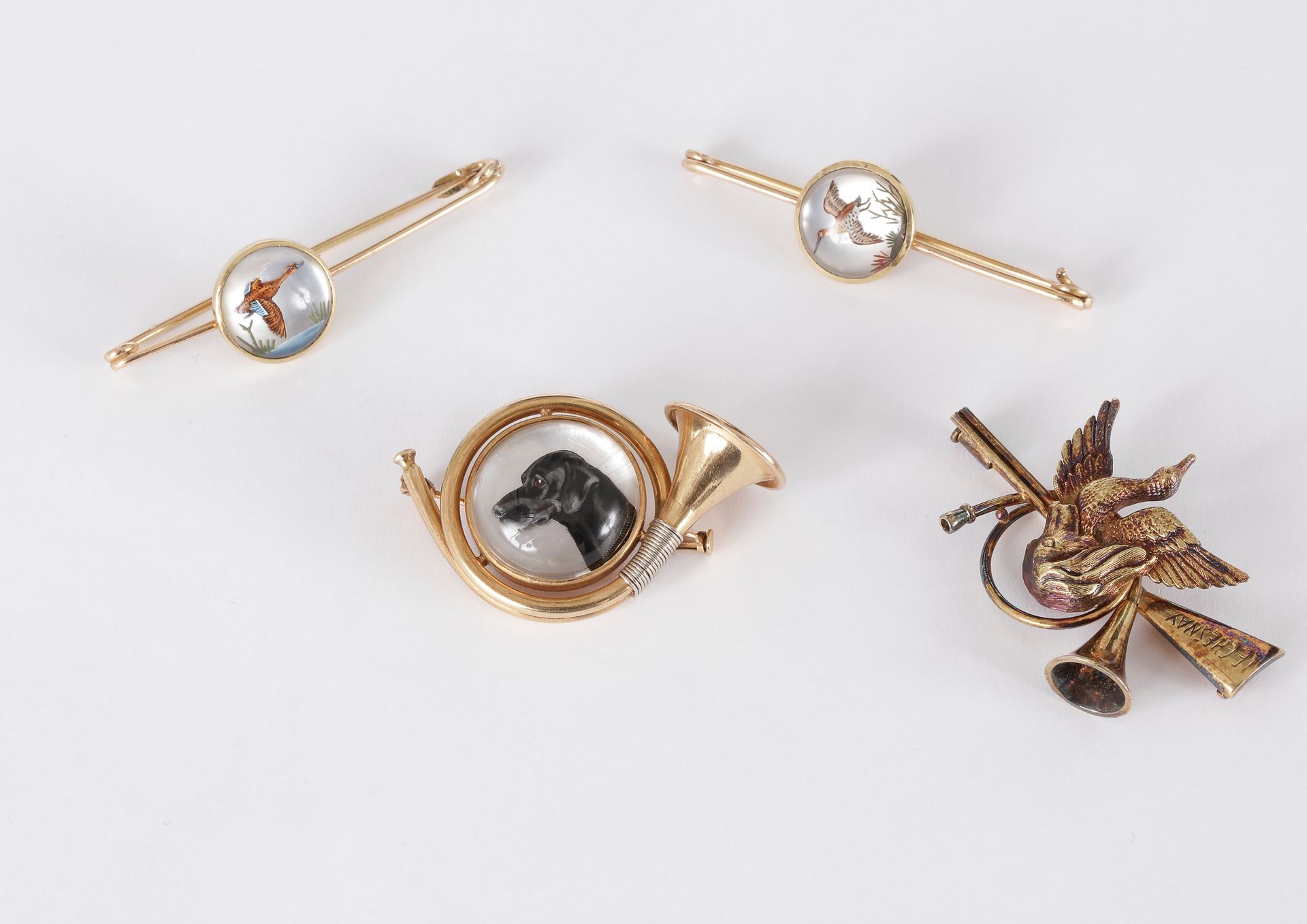 
Suite de bijoux cynégétiques en or 18K (750) et verre églomisé comprenant : 2 épingles ornées chacune d’un oiseau, une broche formant un cor de chasse ornée d’un chien 14K (585)




Poids brut : 31,5 g (on joint une broche en argent doré)
