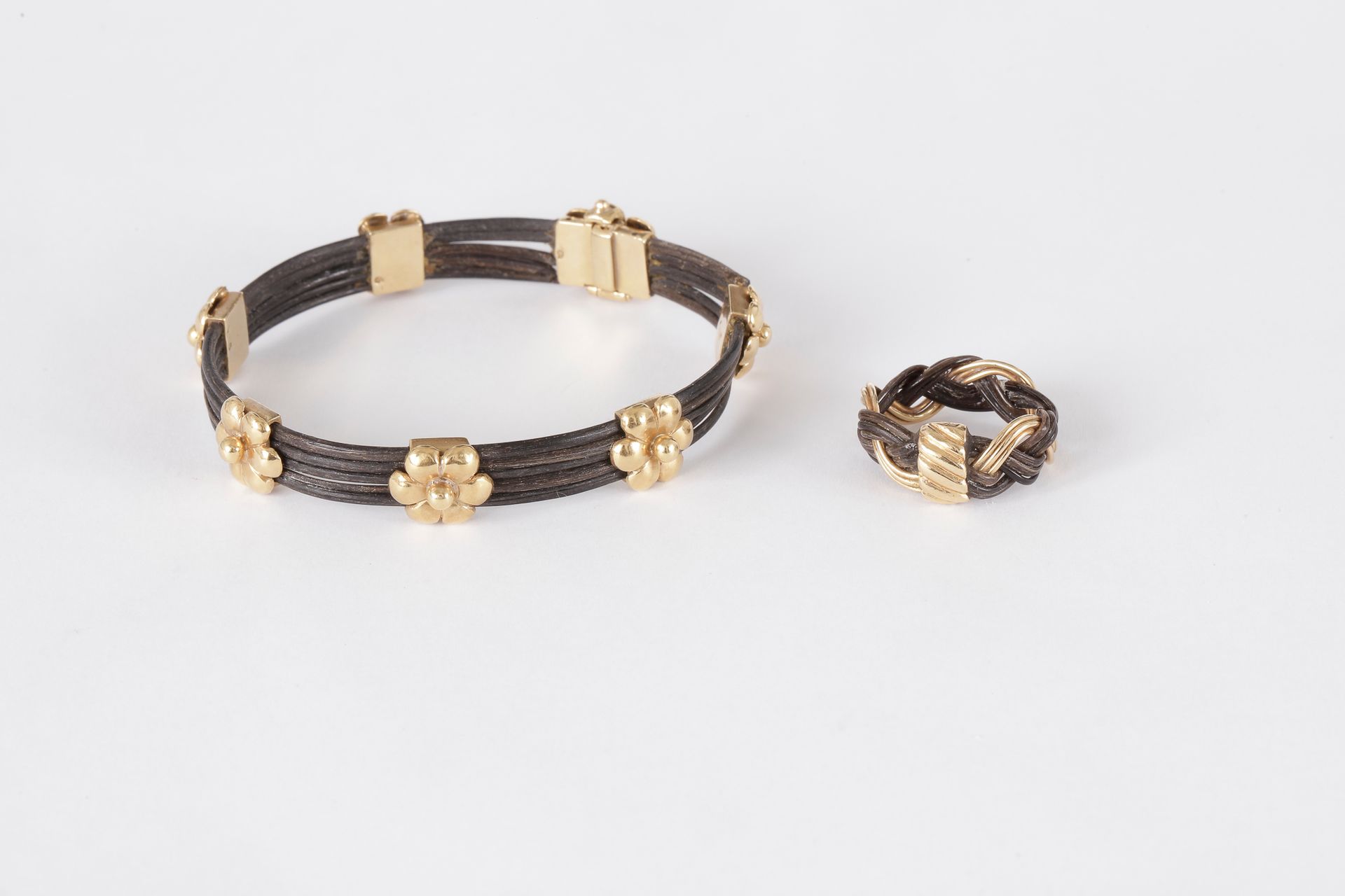 Lot de bijoux en poils d’éléphants montés en or 18K (750) comprenant : une bague tressée et un bracelet ouvrant.

Diamètre : 6 cm. Tour de doigt : 51/52. 

Poids brut : 20,4 g (accidents, colle)