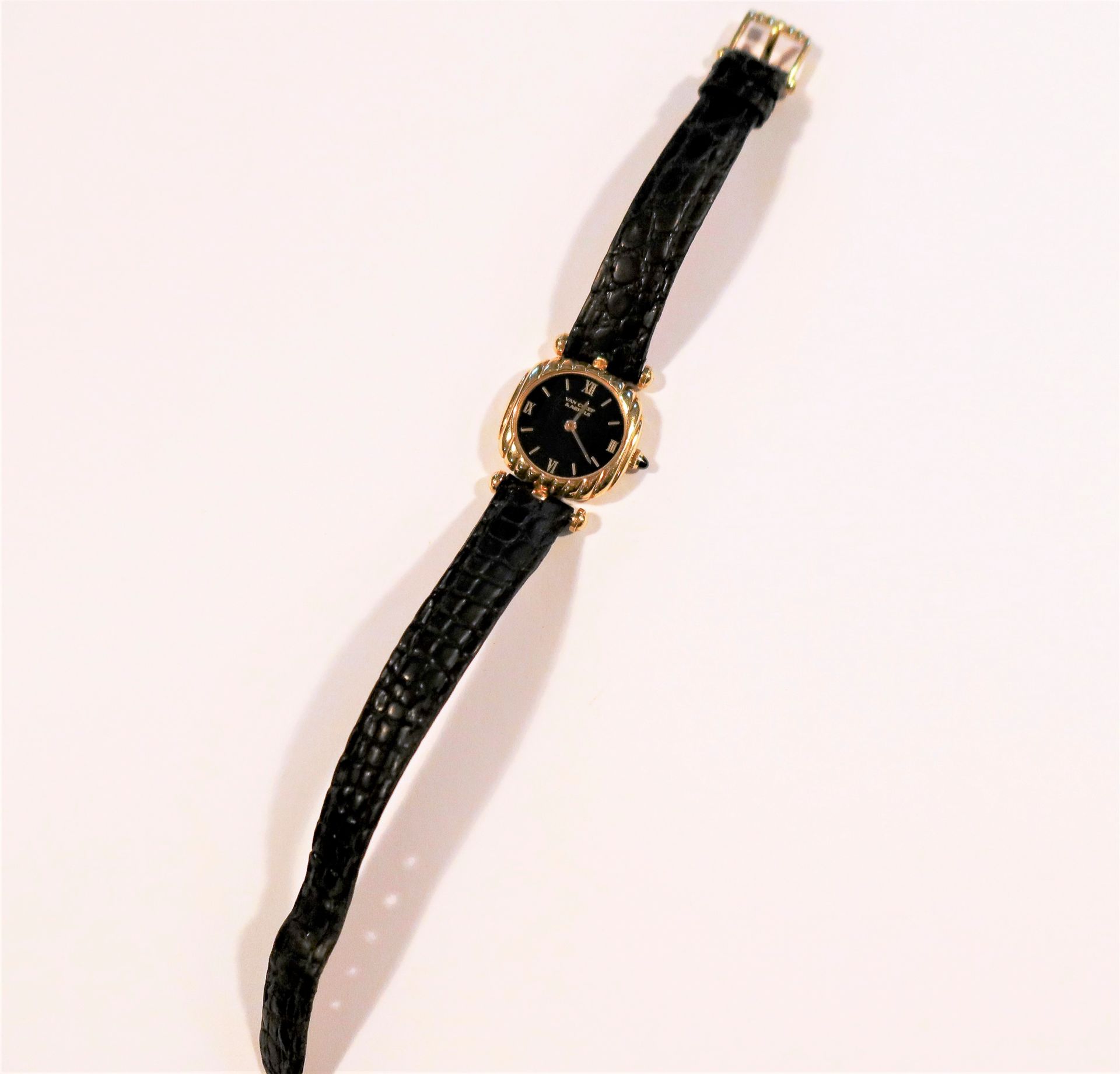 Van Cleef & Arpels 

Montre bracelet pour femme en or 18K (750), cadran noir, mouvement à remontage mécanique, bracelet cuir avec sa boucle ardillon en or 18K signée.

Poids brut : 22,5 g