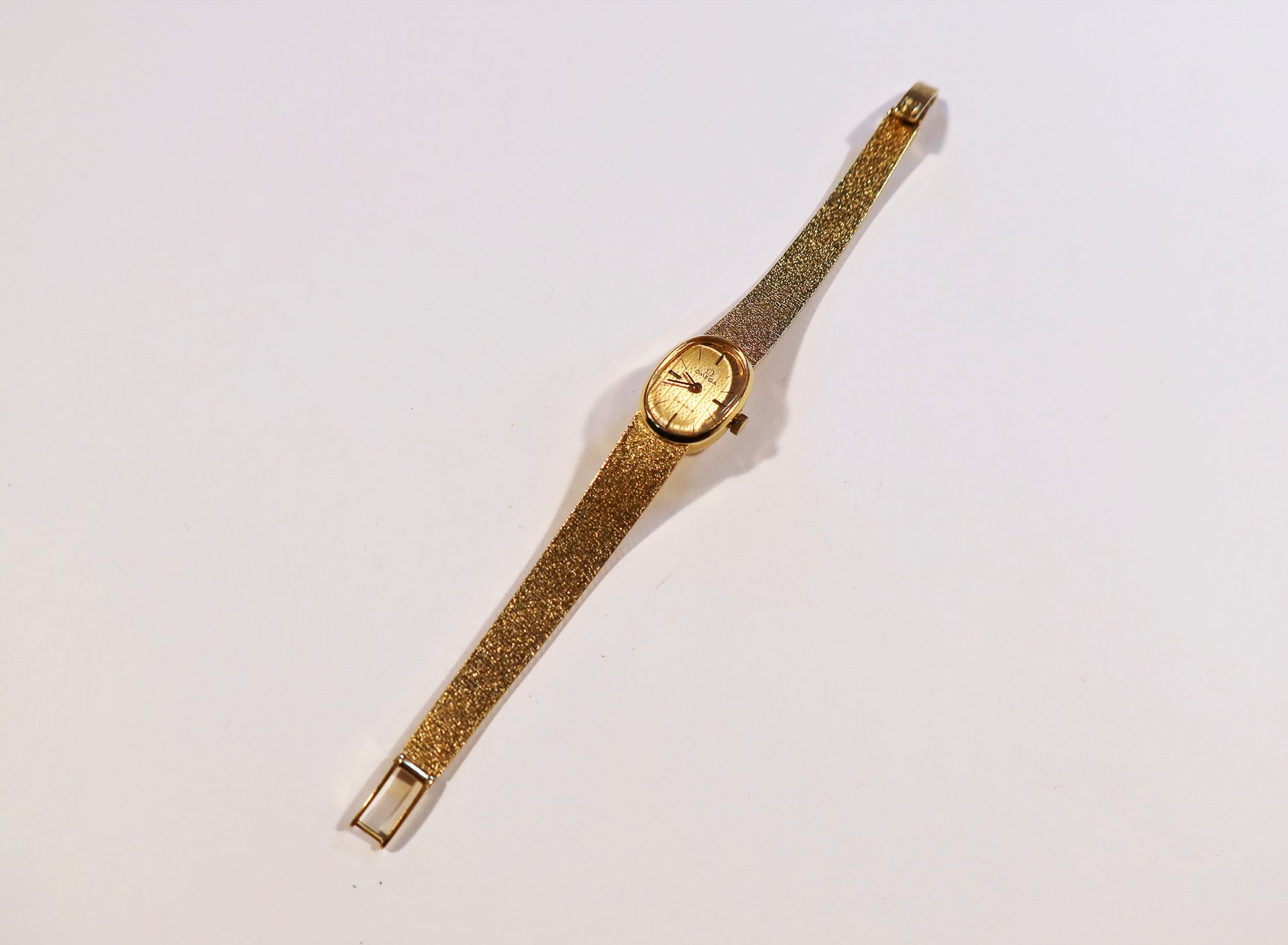 OMEGA. Vers 1960

Montre bracelet pour femme en or 18K (750), cadran doré, index bâtons appliqués formant les heures, mouvement à remontage mécanique, bracelet intégré en or 18K.

Poids brut : 31 g