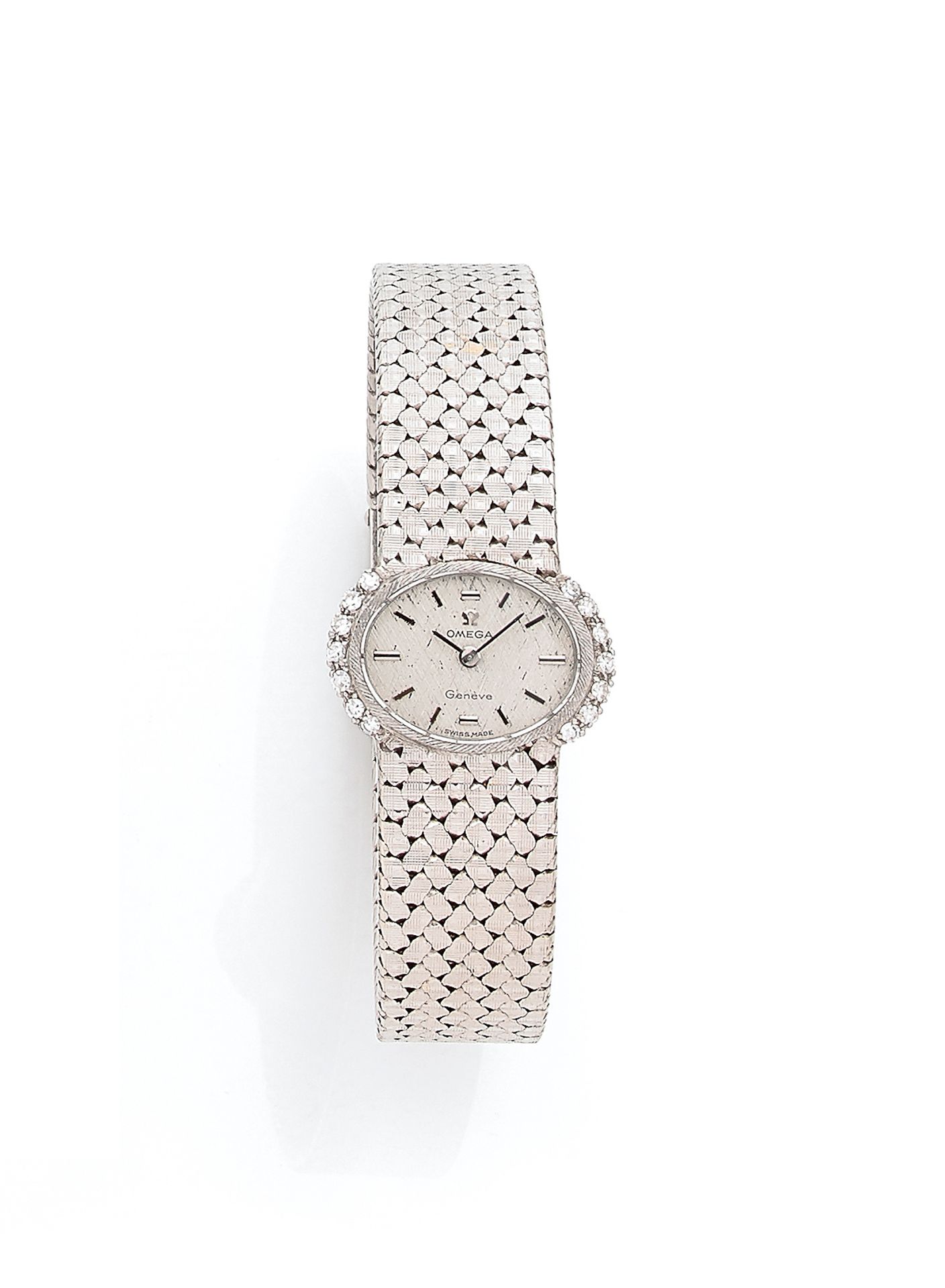 OMEGA. Vers 1970

N° BC 8202

Montre bracelet pour femme en or gris 18K (750), lunette sertie de diamants taille brillant, cadran gris, index bâtons appliqués formant les heures, mouvement à remontage mécanique calibre 484, N° 26057356, bracelet intégré en or avec sa boucle signée.

Cadran, boîtier et mouvement signés.

Longueur : 17,5 cm

Poids brut : 50,4 g