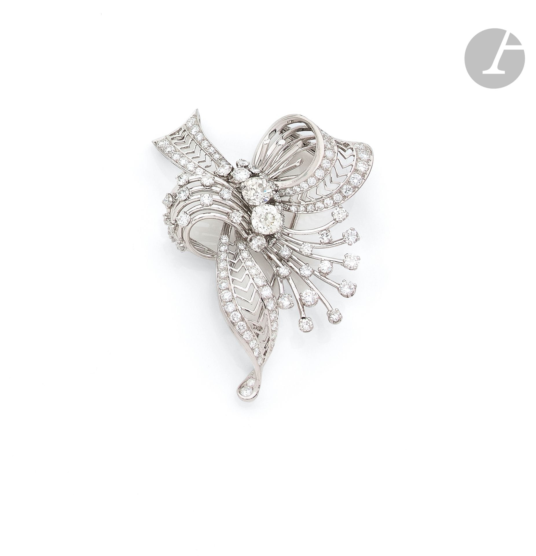 Platinum and 18K (750 ‰) white gold clip brooch drawing a spray, entirely set with round brilliant and 8 / 8 diamonds, the two most important round and cushion old cut. French work of the 1950s. Height : 6,5 cm approximately. Gross weight : 35,1 g (shocks)