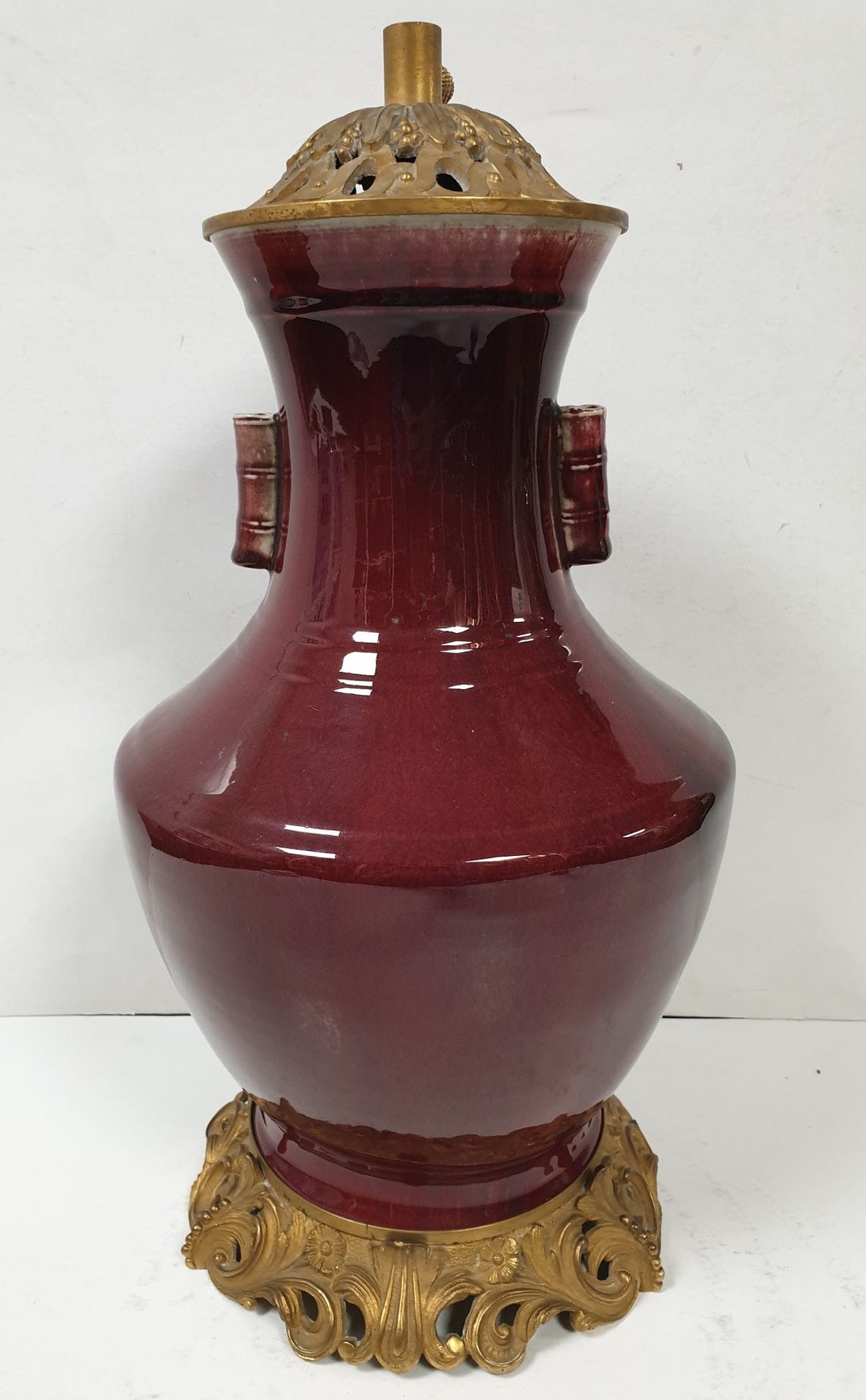 CHINE, fin XIXe / début XXe siècle
Vase en porcelaine à col évasé à décor émaillé sang de boeuf flammé à deux anses cylindriques.
Monture en bronze doré.
Hauteur totale : 48 cm ; hauteur du vase : 37 cm
Percé pour l'électricité.
Etat de la porcelaine sous monture non garanti.