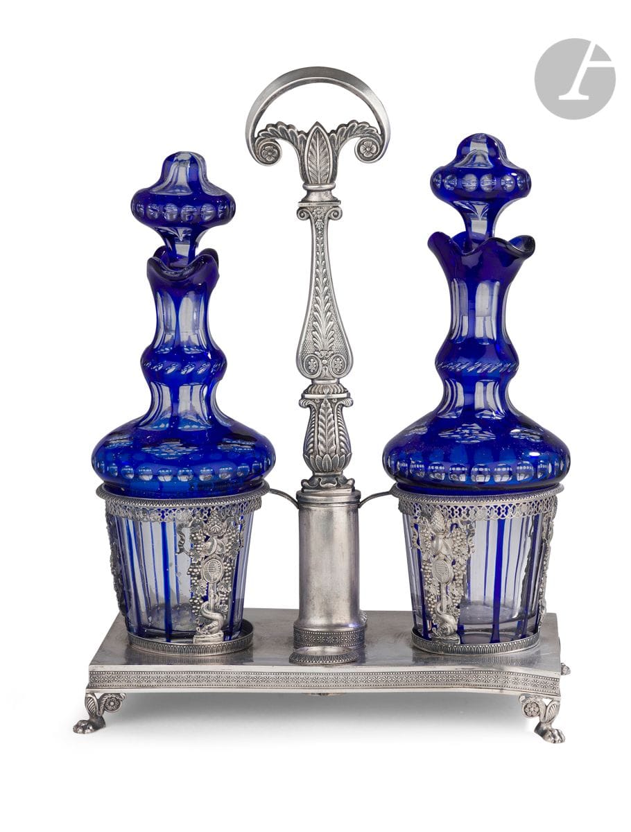 
FRANCE 1819 - 1838



Huilier vinaigrier en argent et une paire de flacons en cristal taillé bleu. Il repose sur une base rectangulaire de pieds griffe et palmettes, les porte-carafes estampés d’un motif ajouré de grappes de raisin et de dauphins, la prise centrale ornée de motifs feuillagés et d’enroulements.



Poinçon : vieillard et de garantie, repoinçonné à la minerve



Poids : 514 g - longueur : 21,7 cm - largeur : 10,8 cm - hauteur : 30,2 cm



ORFEVRE VAHLAND

ETAT : A REDRESSER, ENFONCEMENT
