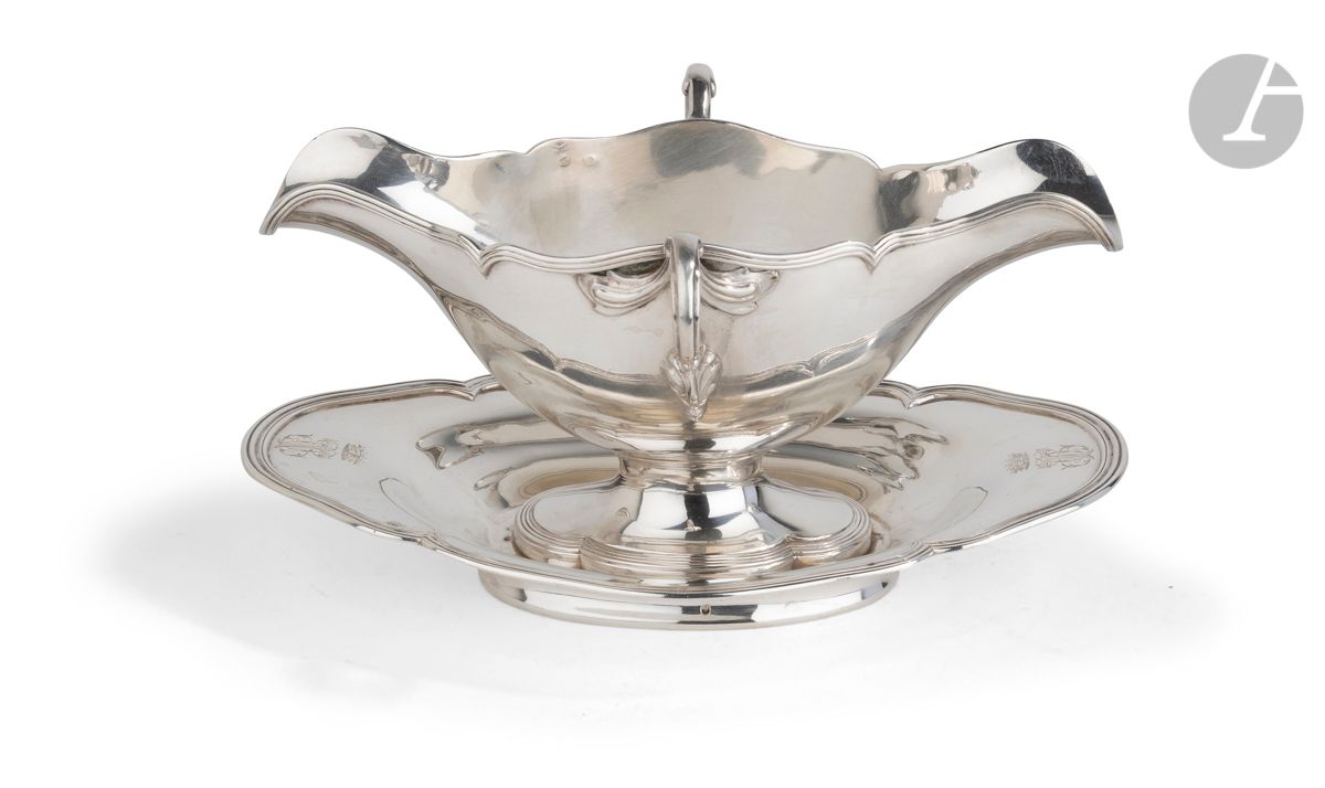 FRANCE XXe SIÈCLE
Saucière de forme ovale en argent reposant sur une bâte et vissée sur son plateau, à deux becs verseurs et deux anses latérales, bordée de filets. Chiffrée d’un monogramme surmonté d’une couronne aux deux extrémités.
Poinçon minerve
Orfèvre : probablement BOULANGER
Poids : 677,1 g - longueur : 13,5 cm - largeur : 25,5 cm