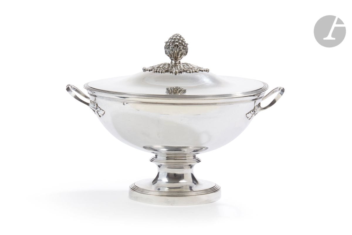 FRANCE DEUXIÈME MOITIÉ DU XIXe SIÈCLE
Soupière en argent de forme ovale, elle repose sur un piédouche de même forme mouluré de rangs de filets en rappel sur le couvercle, le corps et le couvercle gravés en lettres gothiques AP, sommé d’une pomme de pin sur sa terrasse de feuilles (amovible). Les deux anses à point central et appliques de feuilles d’acanthe.
Poinçon minerve
Orfèvre : illisible
Poids net : 2307,3 g - longueur : 38,2 cm - largeur : 23 cm
