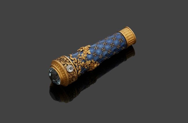 
FRANCE FIN DU XIXe SIÈCLE



Pommeau de canne en vermeil, émail bleu, aigue marine et diamants taillés en rose. Le corps est émaillé de losanges rehaussés de petits diamants formant un motif de fleurs et de draperies de fleurs surmontées de nœuds de style Louis XVI. Deux diamants sertis sont encadrés de motifs de lauriers fleuris sommés d’une aigue marine taillée.



Poinçons : ouvrage mixte et au hibou



Poids brut : 96,4 g - hauteur : 9,5 cm



.
