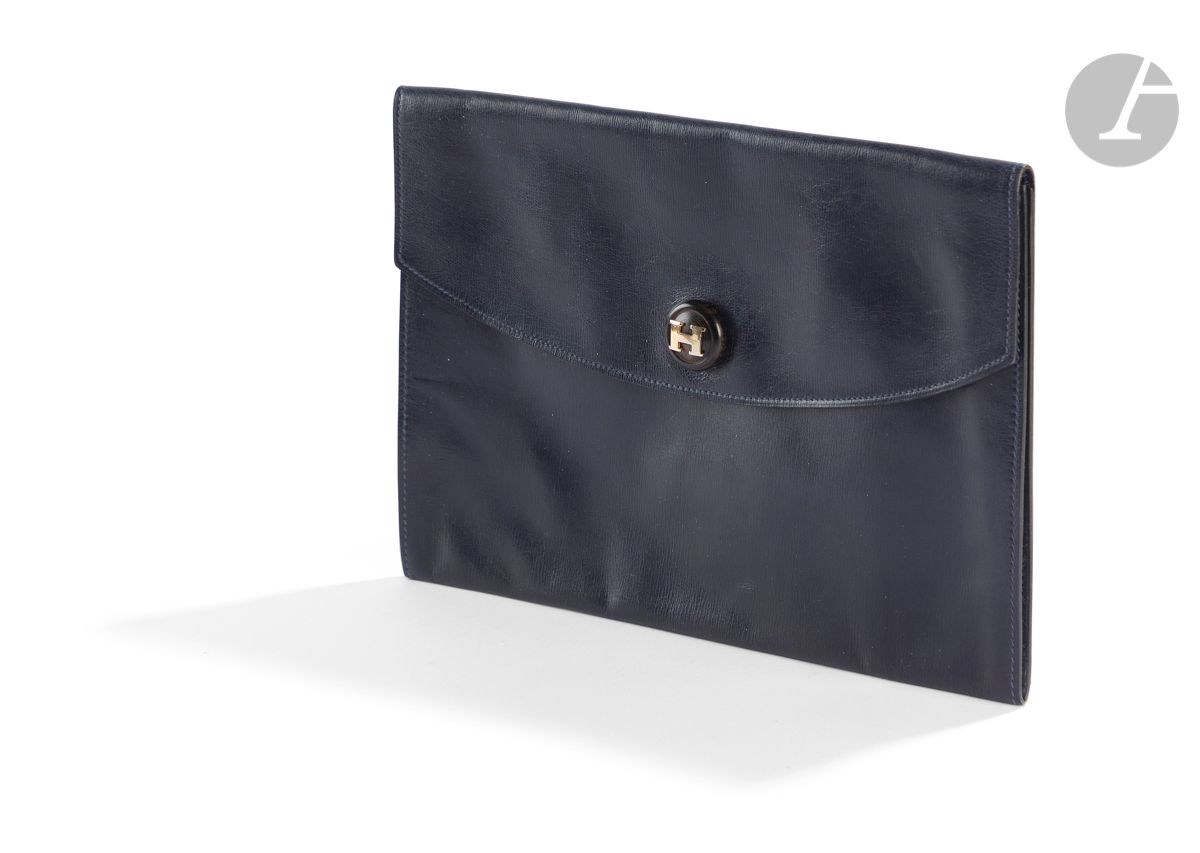 HERMES Paris Made in France
Pochette Rio en cuir marine (traces d'usage), bouton pression en bois surmonté d'un H plaqué or, années 70-80
24 x 17 cm